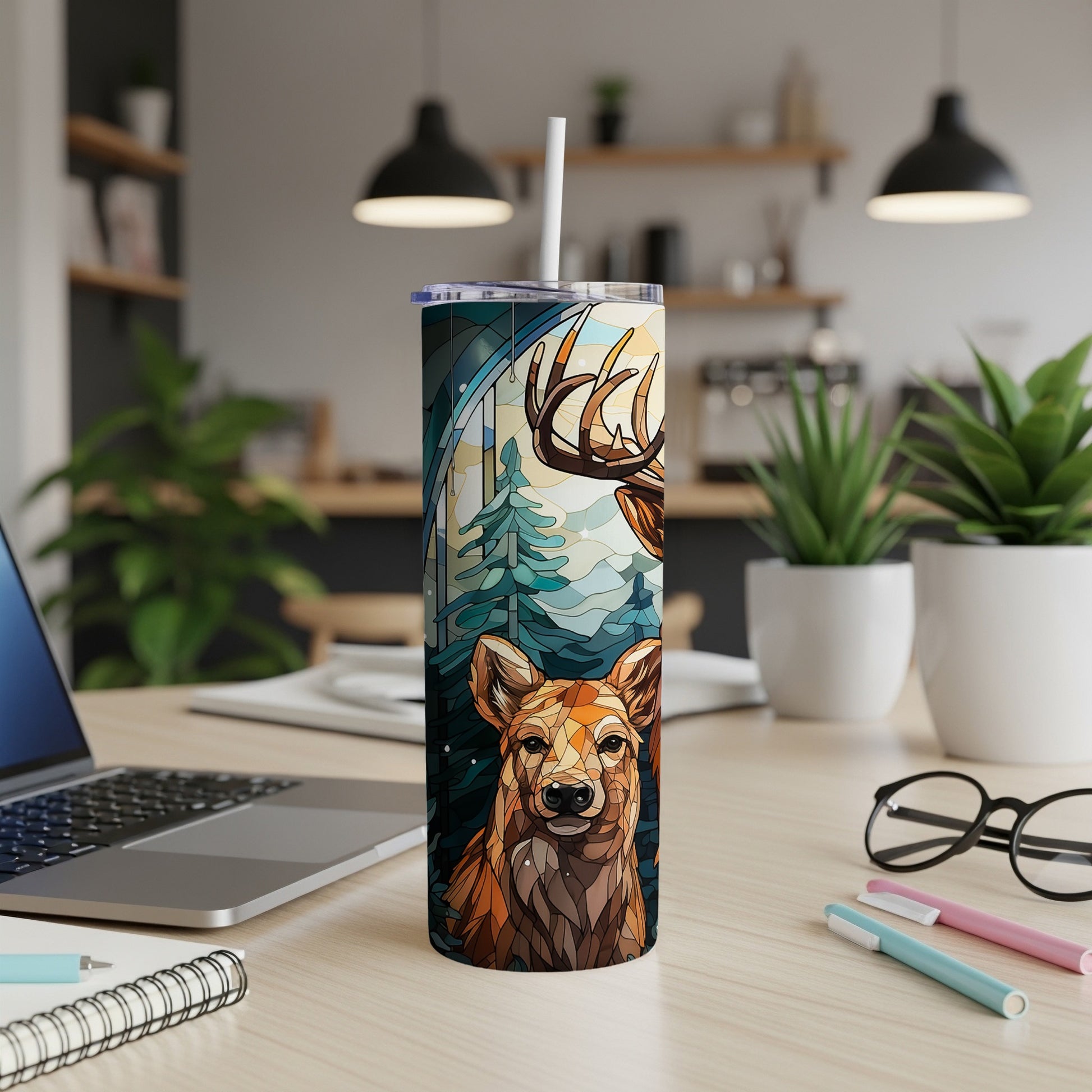 Woodland animal art on a tumbler with a straw, on a desk.