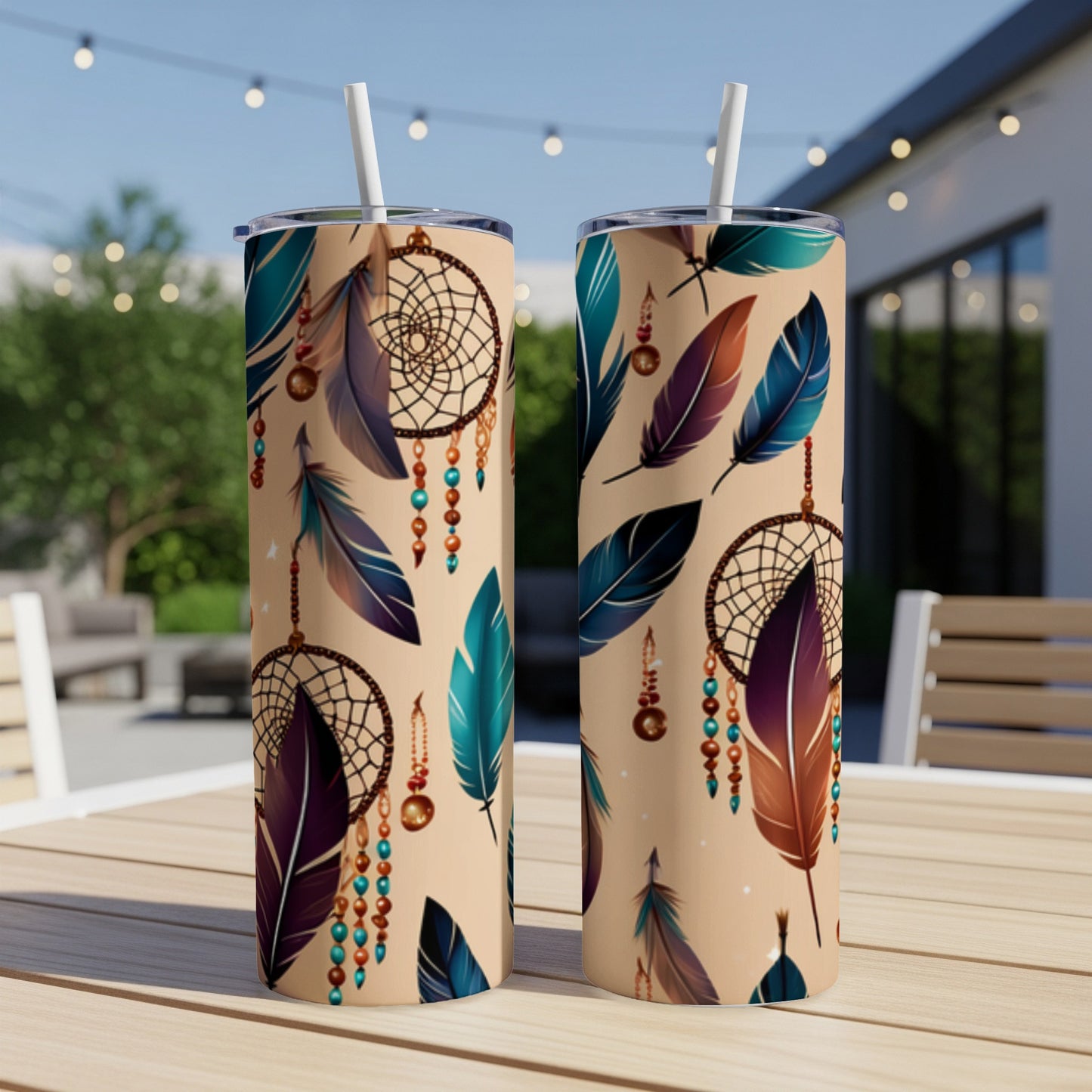 Two tan tumblers with dreamcatcher and feather design on outdoor table.