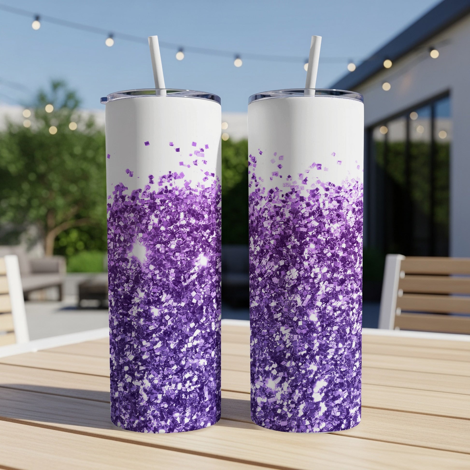 Two glitter-covered tumblers with purple ombre design on a wooden table.