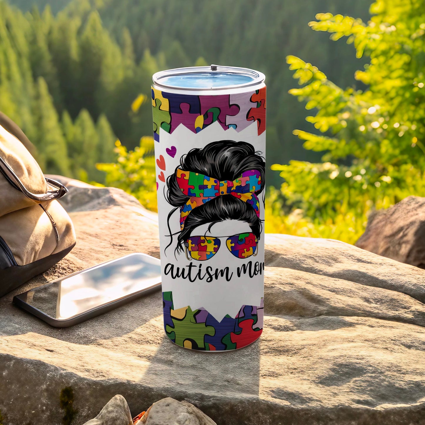 Tumbler with colorful puzzle piece design and "autism mom" text.