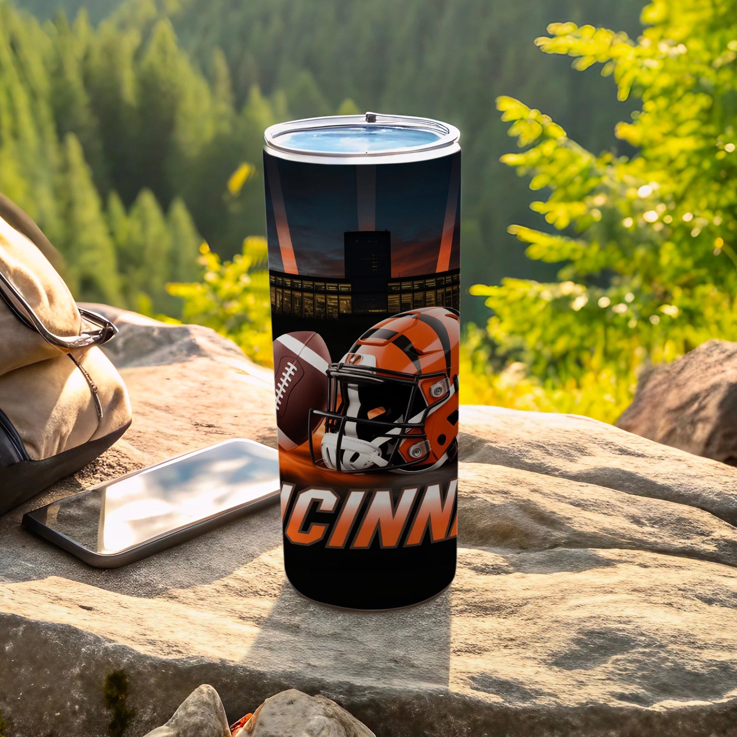 Cincinnati Bengals football helmet and ball on tumbler with mountain background.