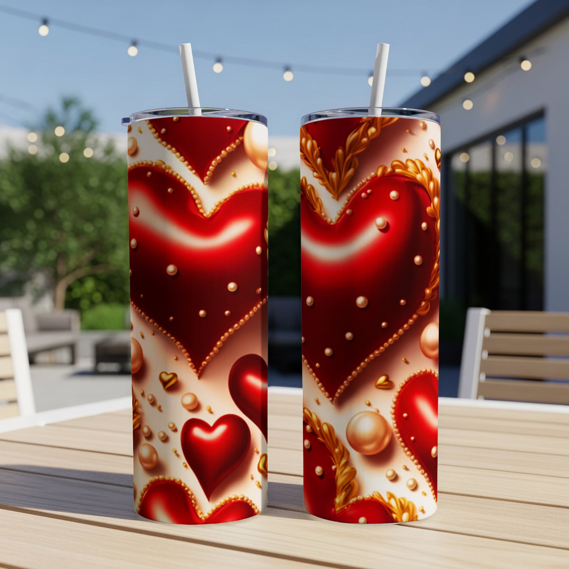 Two red heart patterned tumblers with gold accents sit on a table.