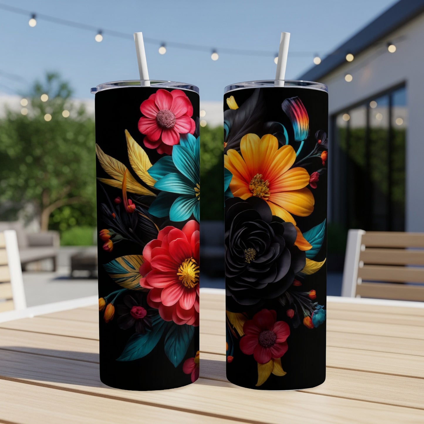 Two black tumblers with vibrant floral designs on a wooden table.