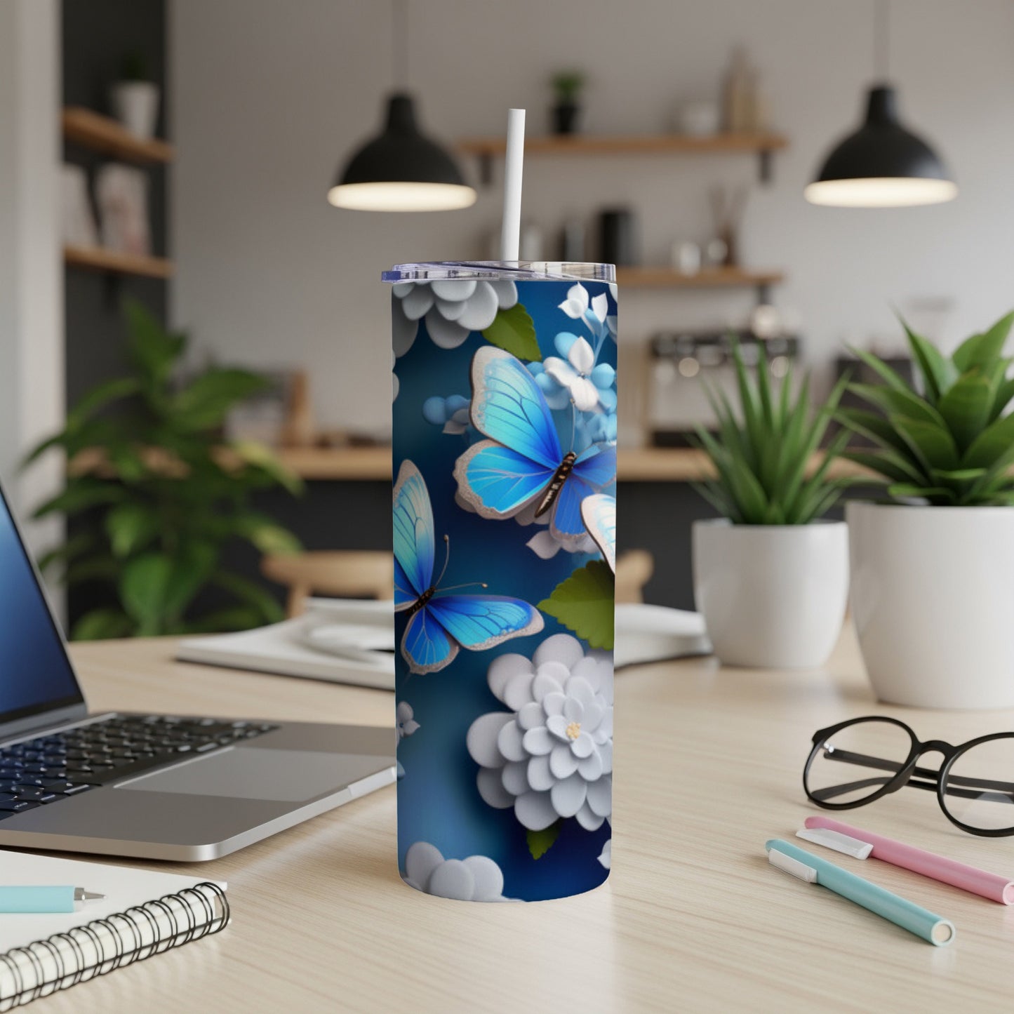 Blue butterflies and white flowers on a dark blue background decorate a tumbler with a straw.