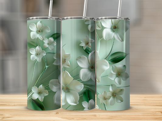 Three mint green tumblers with a white floral design and straws on a wooden surface.