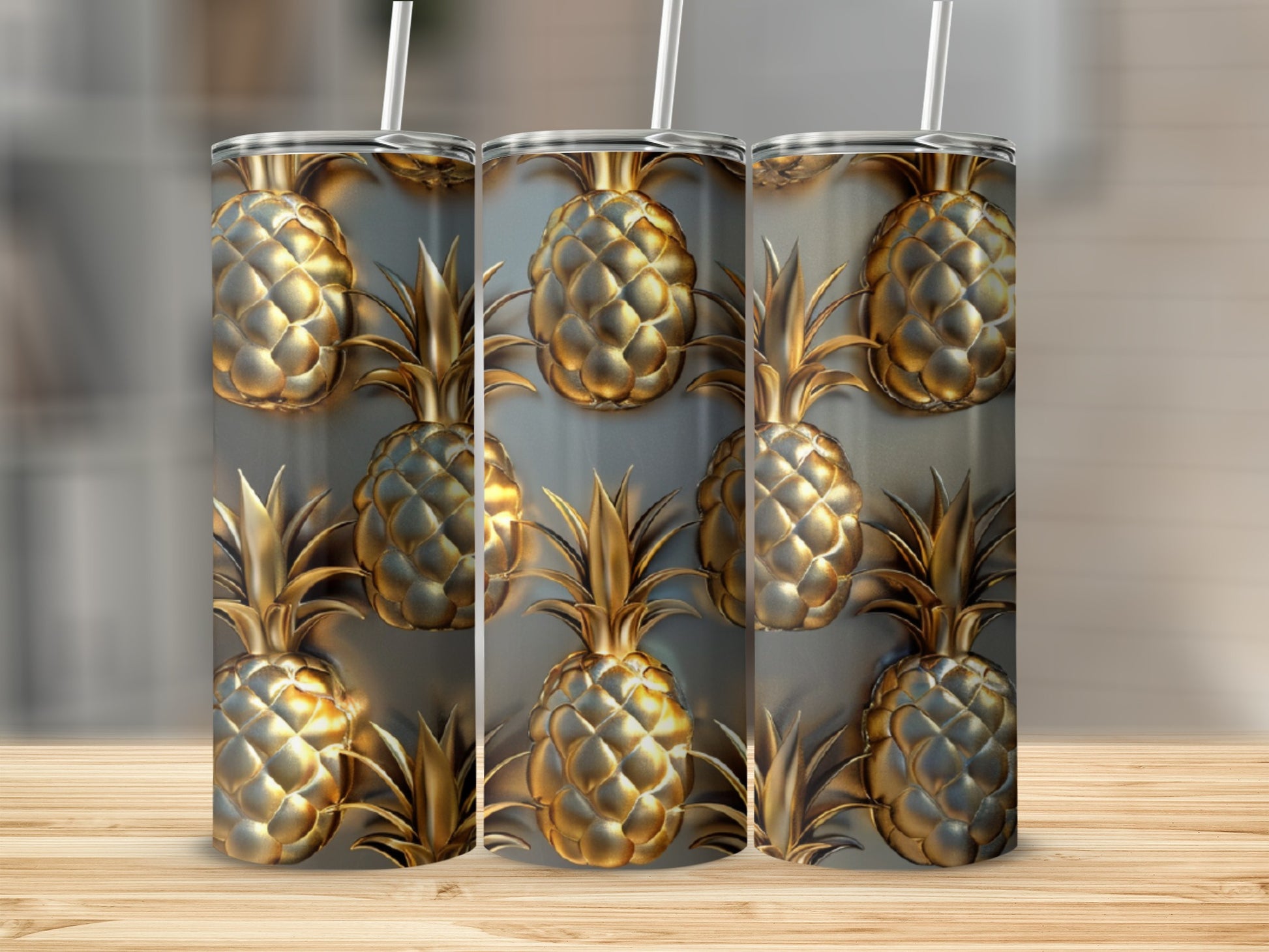 Three tumblers with a repeating gold pineapple pattern on a wooden surface.
