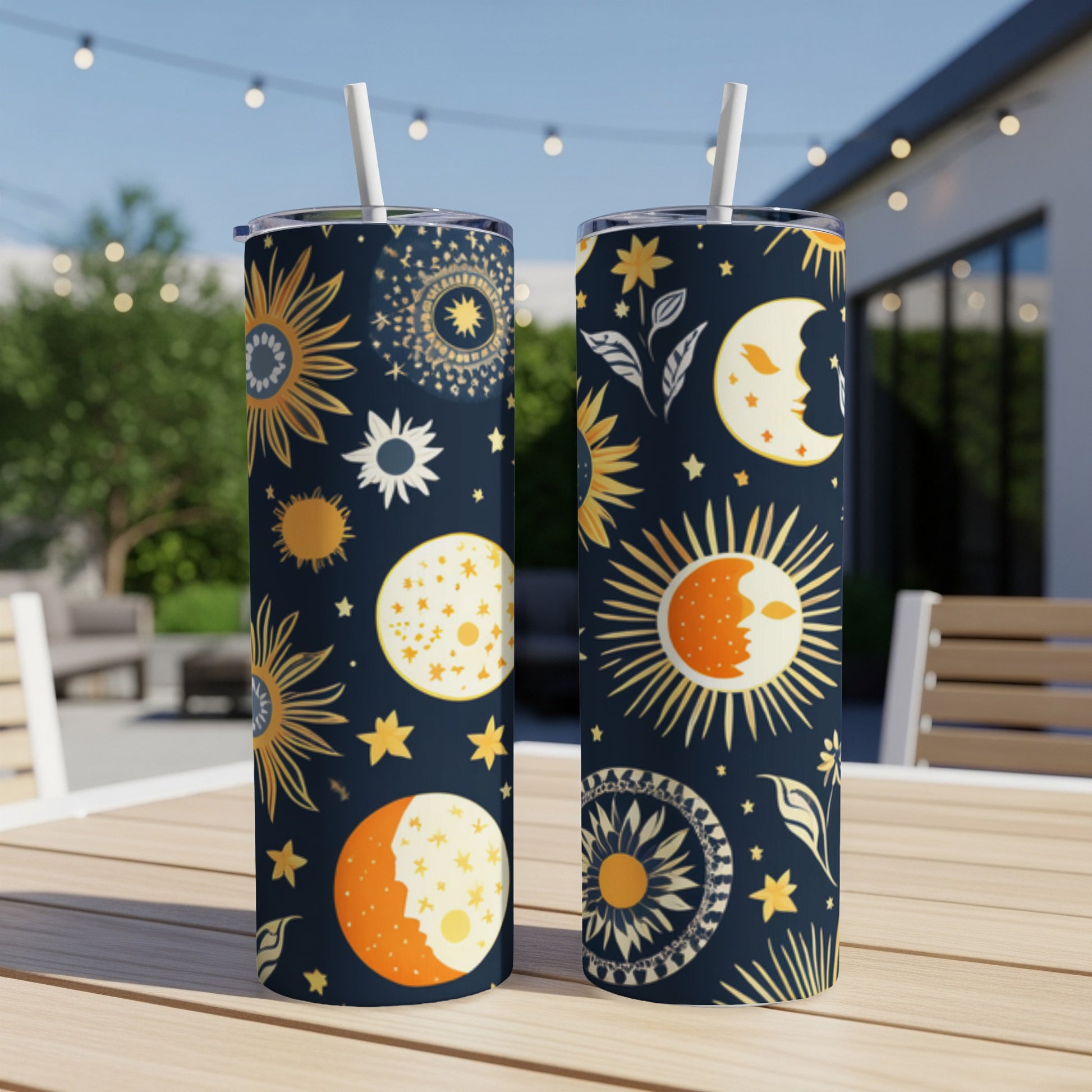 Two tumblers with celestial sun, moon, and star patterns on a table.