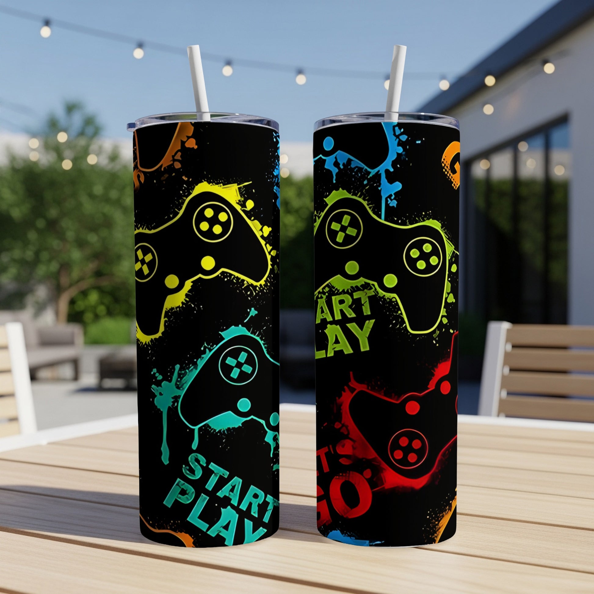 Two tumblers with colorful video game controllers and text against a blurred outdoor background.