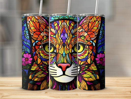 Colorful stained glass cat face tumbler with straw on wooden surface.