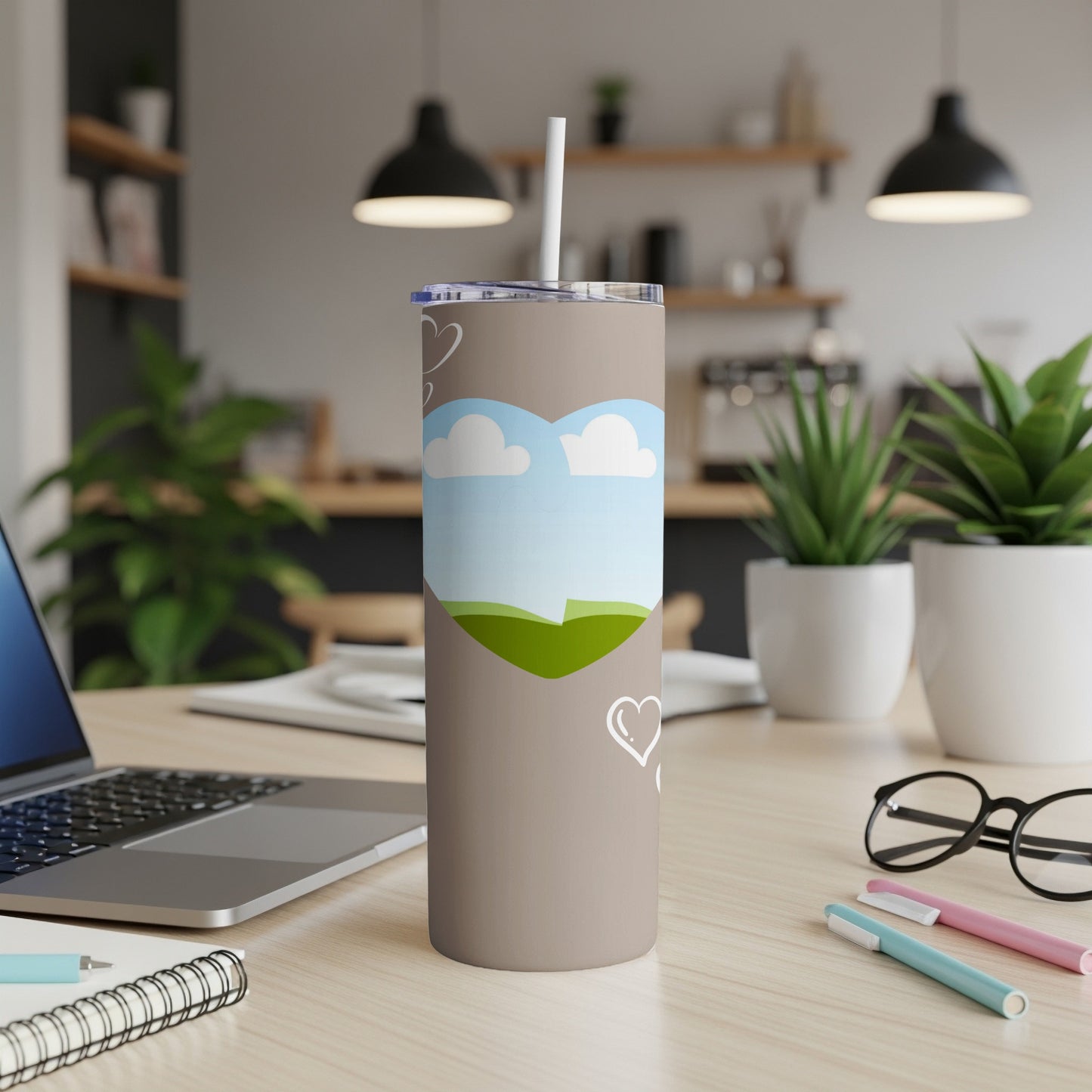 Taupe tumbler with heart-shaped landscape design and white hearts.
