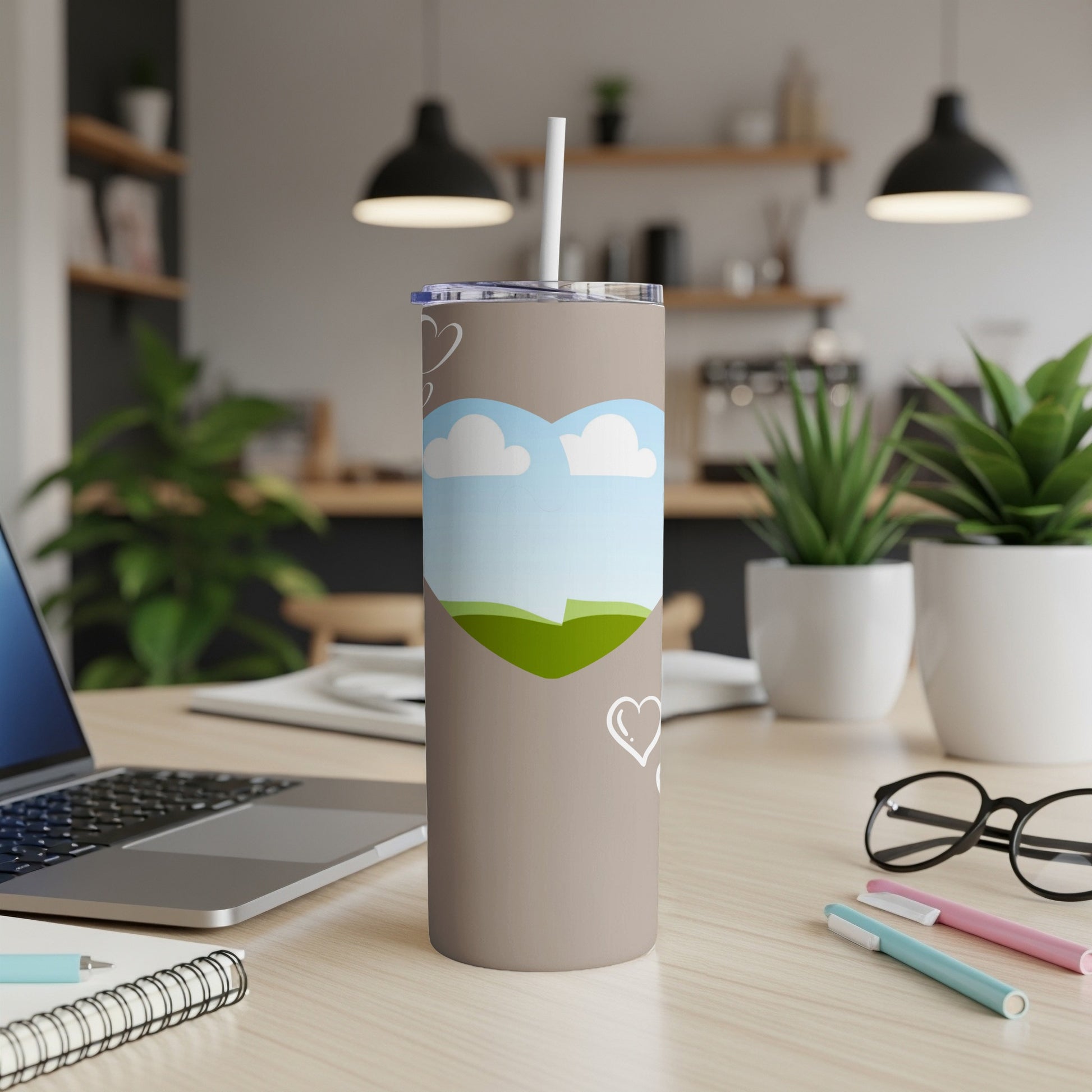 Taupe tumbler with heart-shaped landscape design and white hearts.