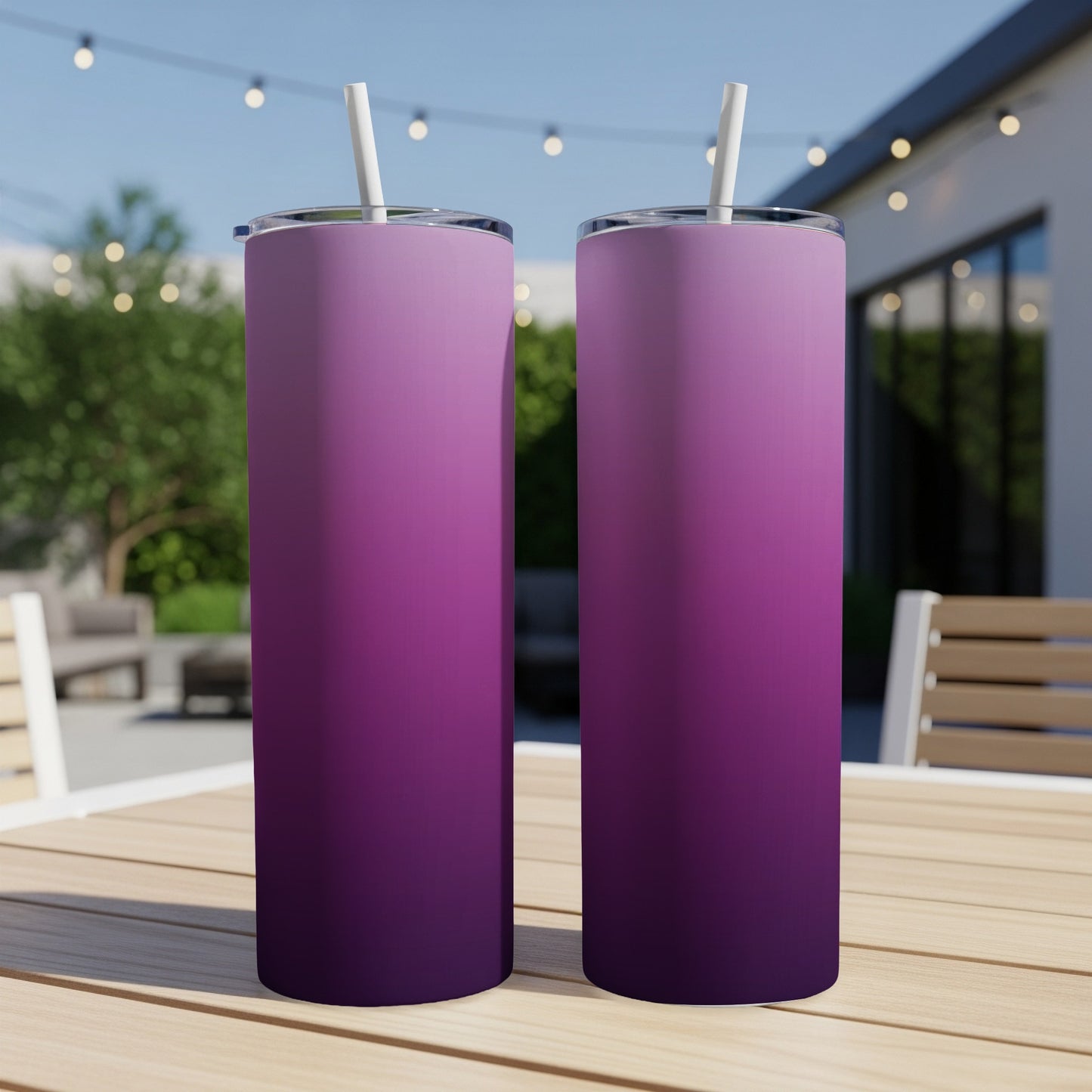 Two tall tumblers with purple gradient design and white straws on a wooden table.