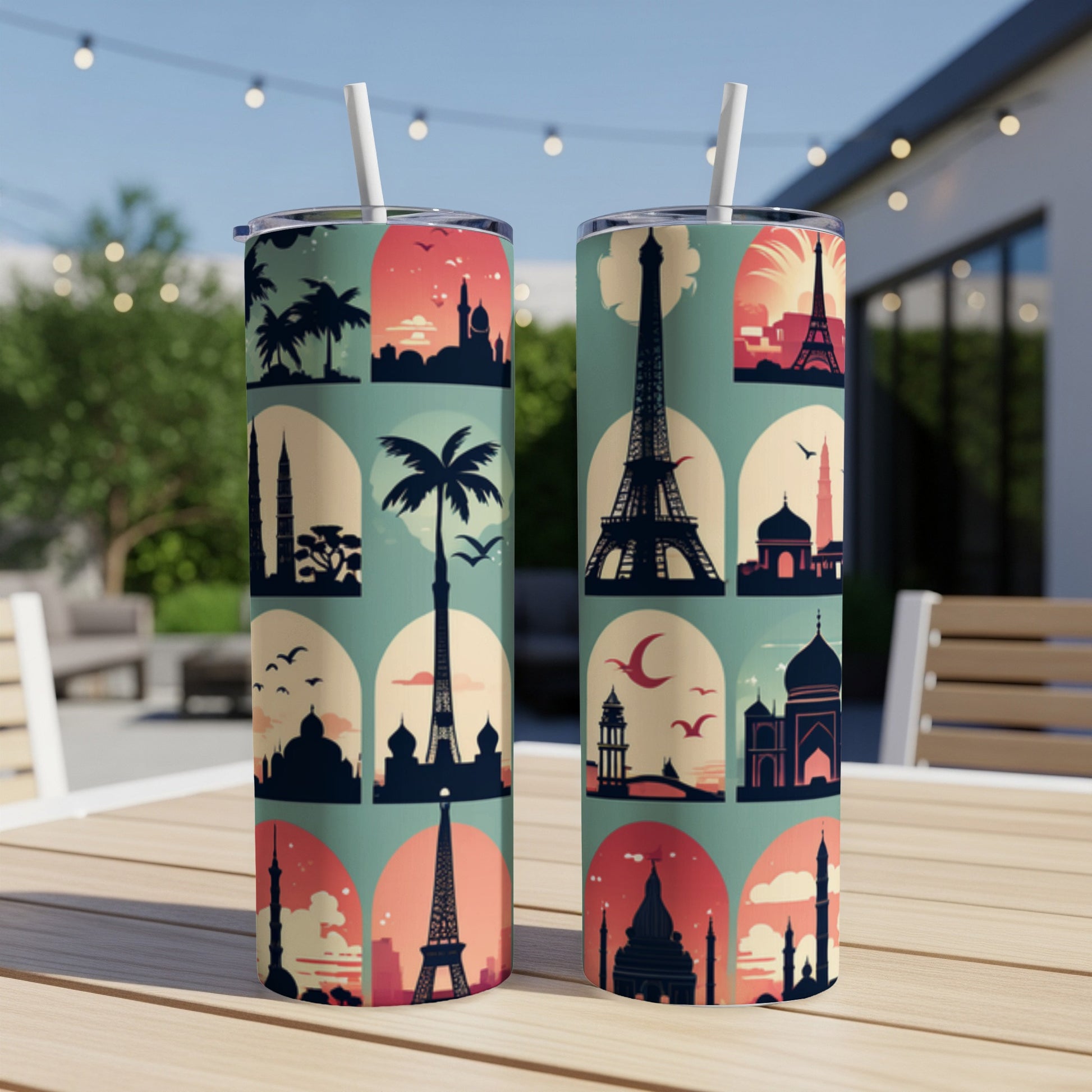 Two colorful tumblers with silhouetted landmark designs on an outdoor table.