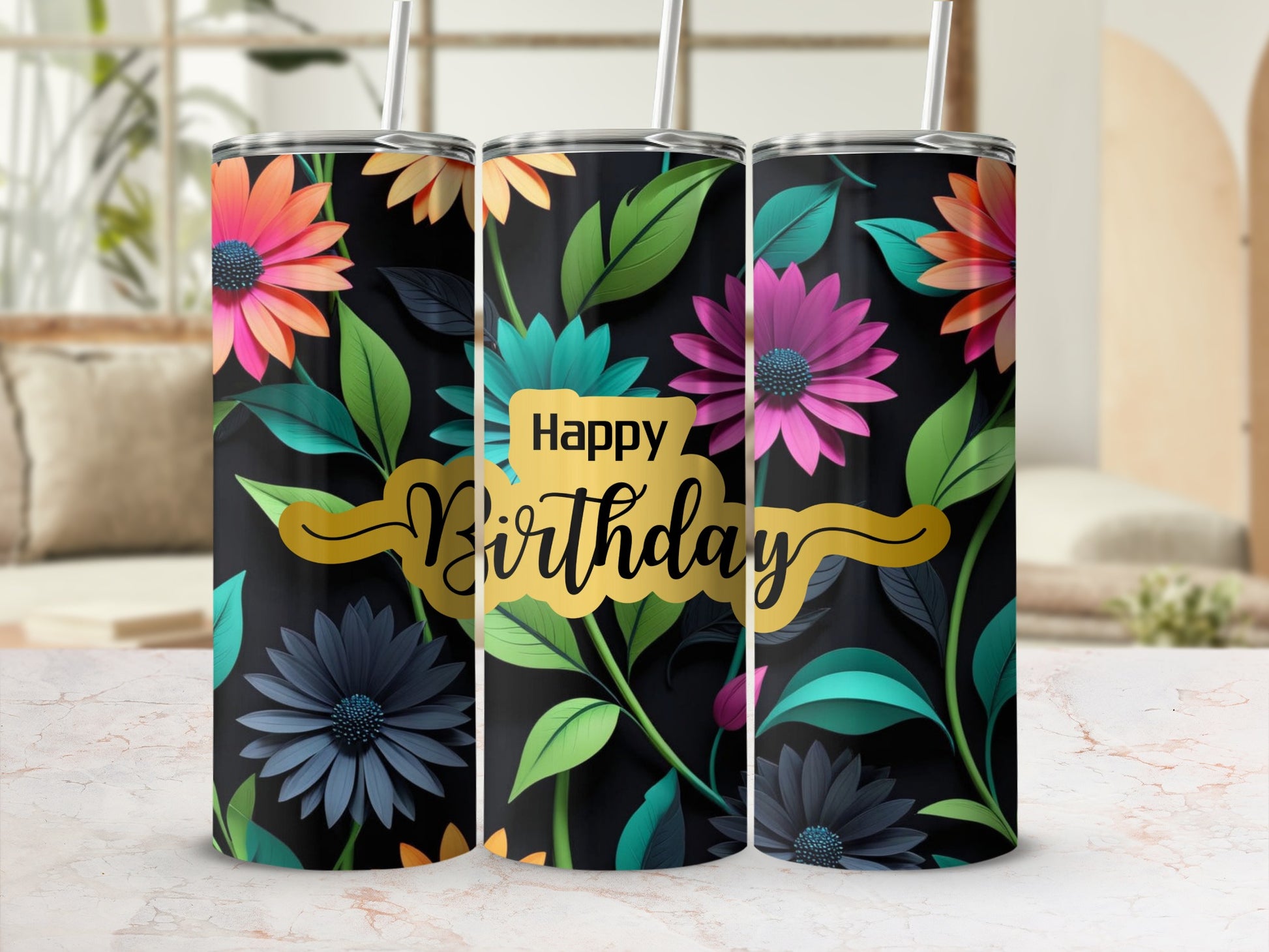 Floral happy birthday tumbler with straw on marbled surface.