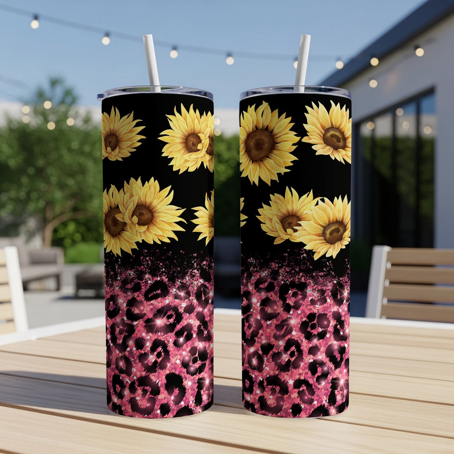 Two tall tumblers with sunflowers and pink leopard print on a table.