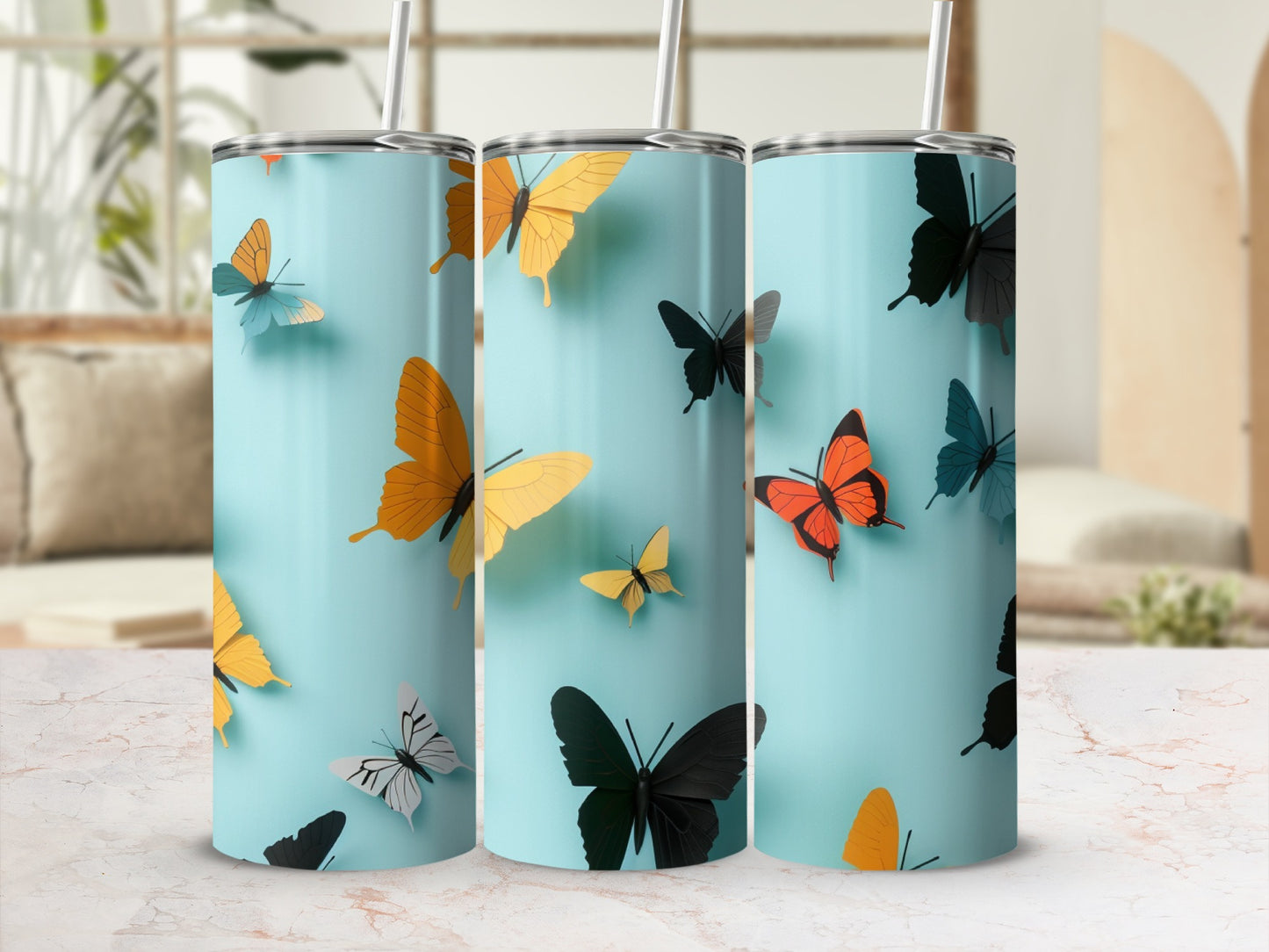 Three tumblers with colorful butterfly designs on a light blue background.