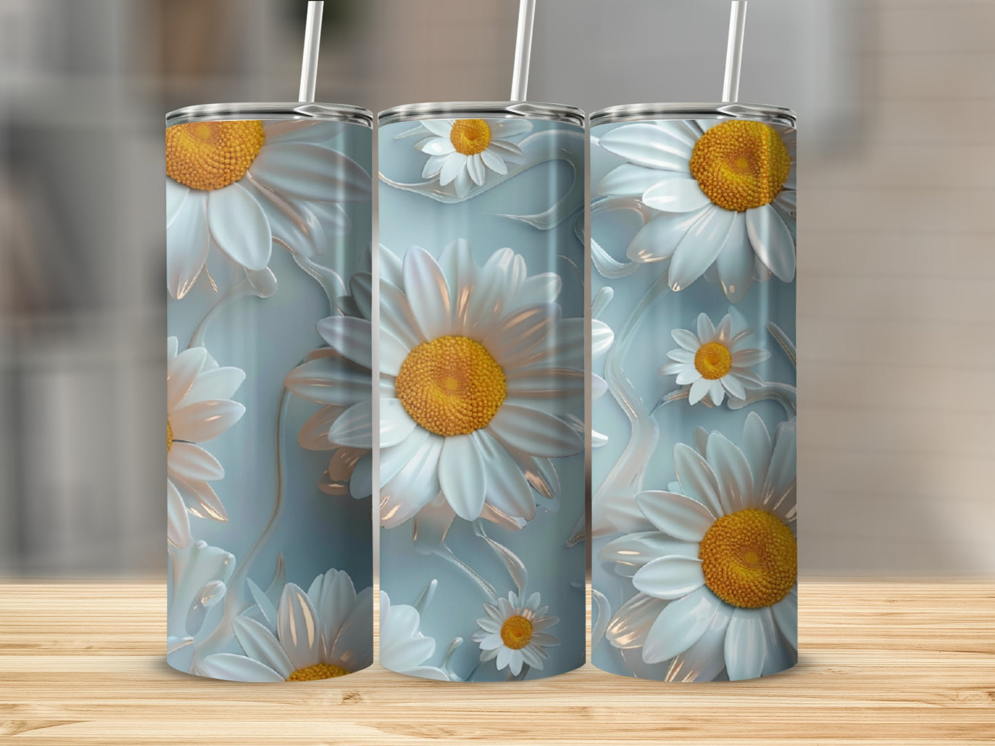 Three tumblers with white daisy floral designs on a light blue background.