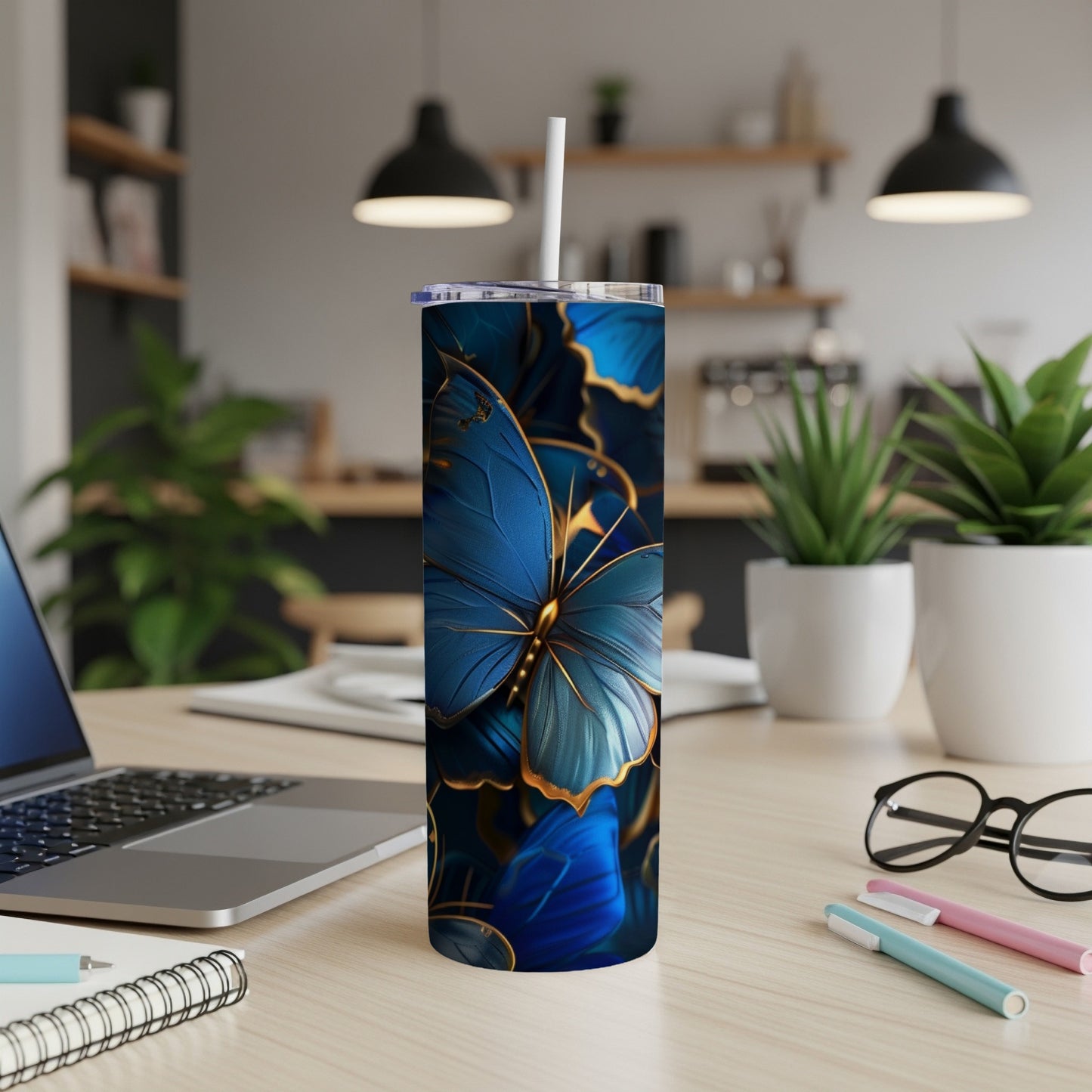 Blue butterfly pattern on a tall, slim tumbler with a straw.