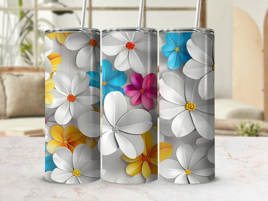 Three floral tumblers with white, yellow, blue, and pink flowers on a grey background.