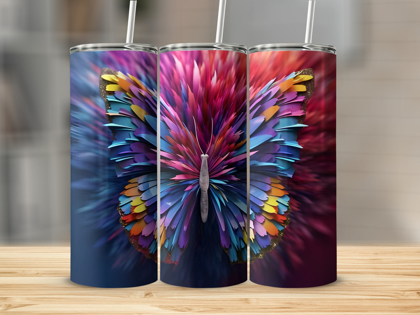 Three colorful butterfly tumblers with straw on a wooden surface.