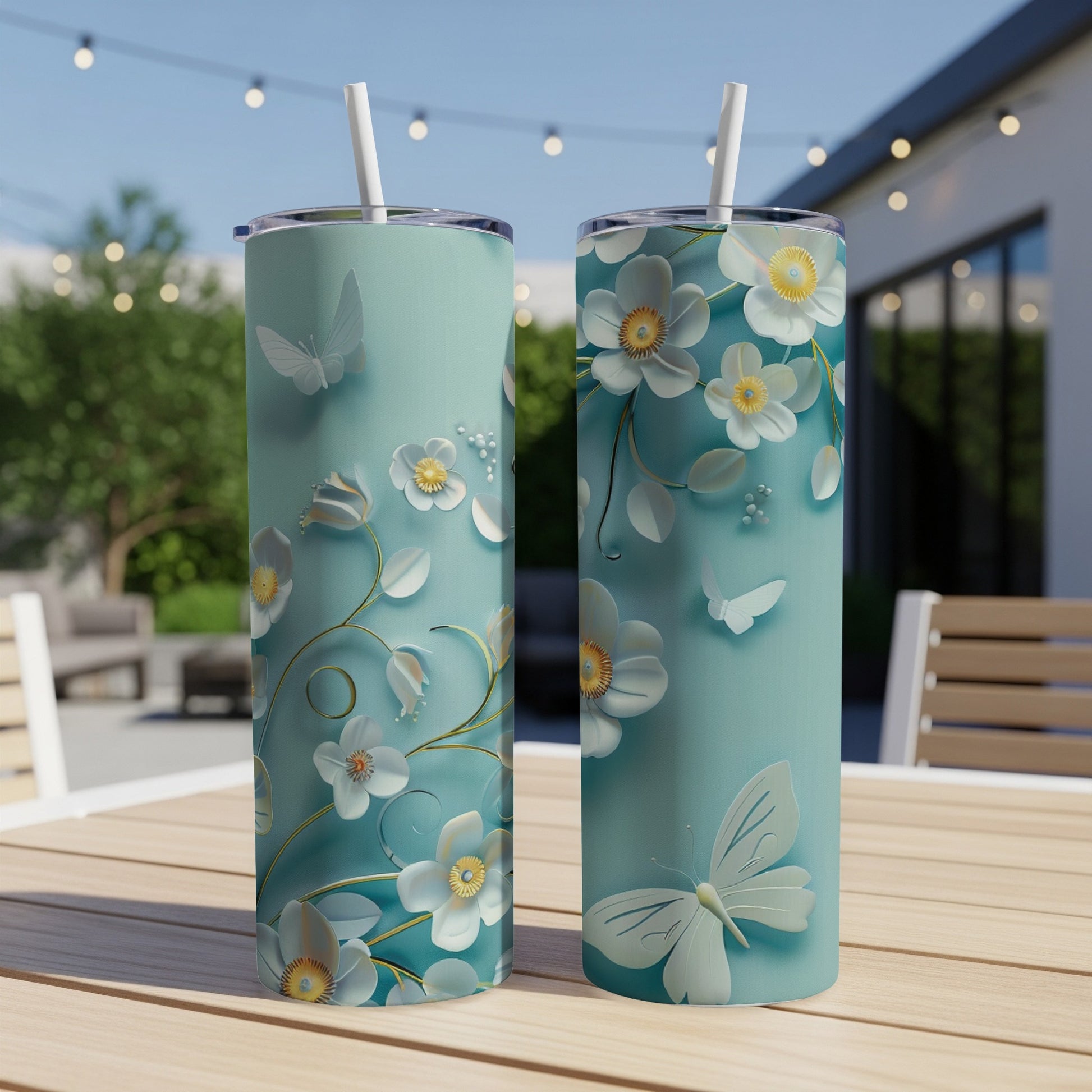 Two mint green tumblers with white floral and butterfly designs.