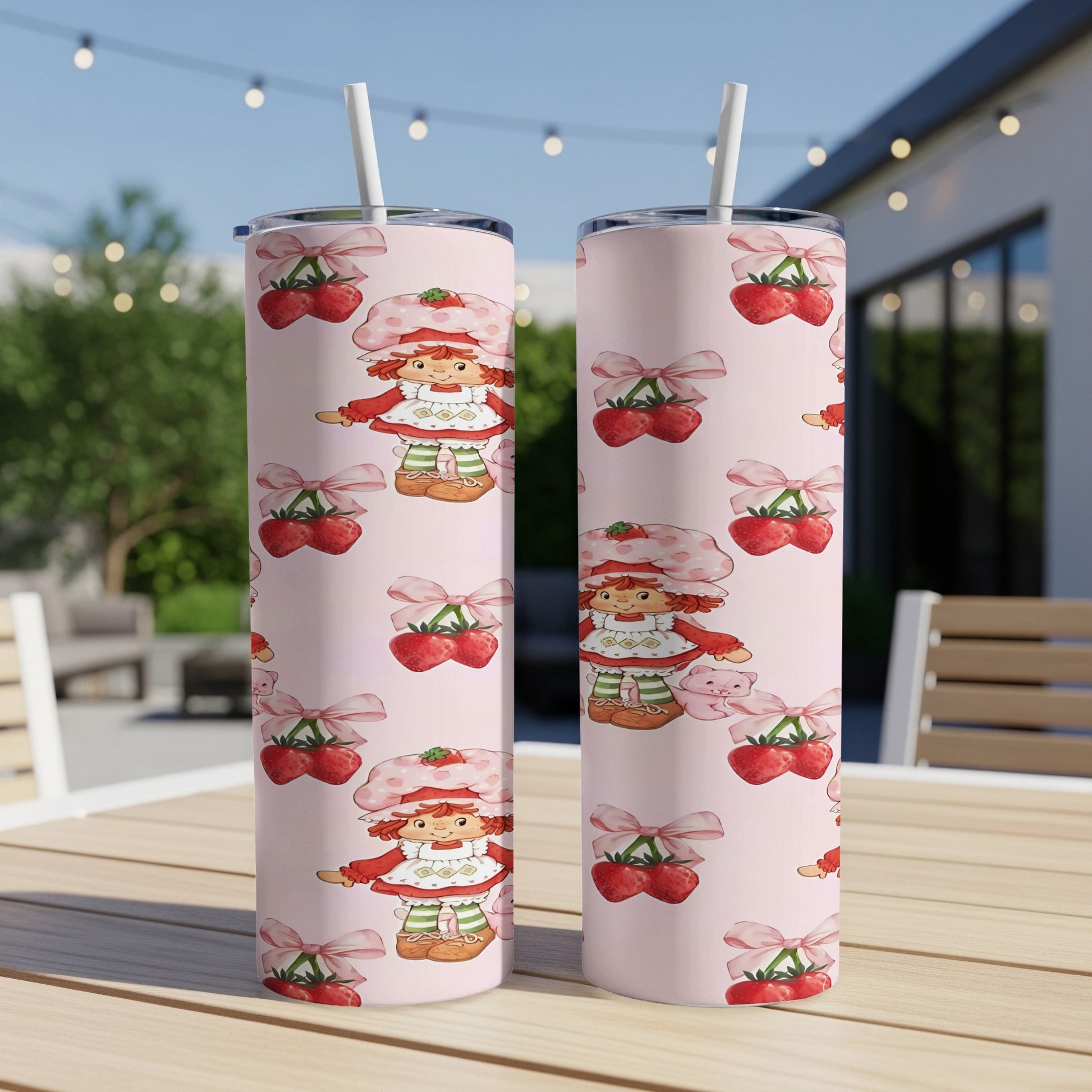 Two pink tumblers with a repeating pattern of Strawberry Shortcake and cherries.