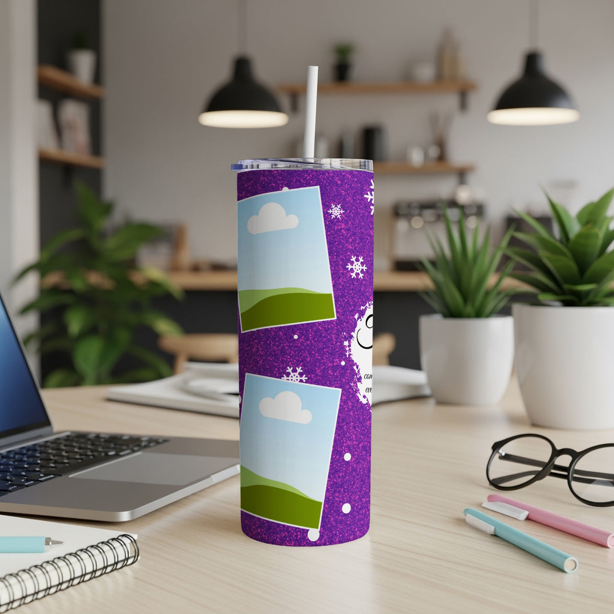 Purple glitter tumbler with picture frames, snowflakes, and text on a desk.