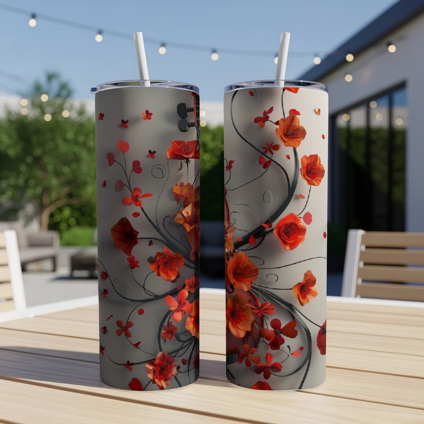 Two tall tumblers with red floral vine designs on a table.