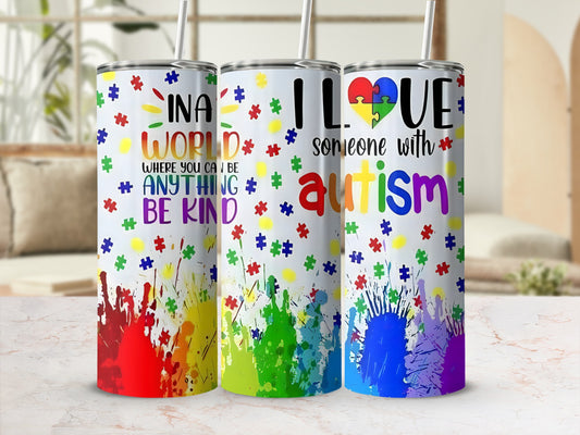 Three colorful tumblers with autism awareness phrases and puzzle piece designs.