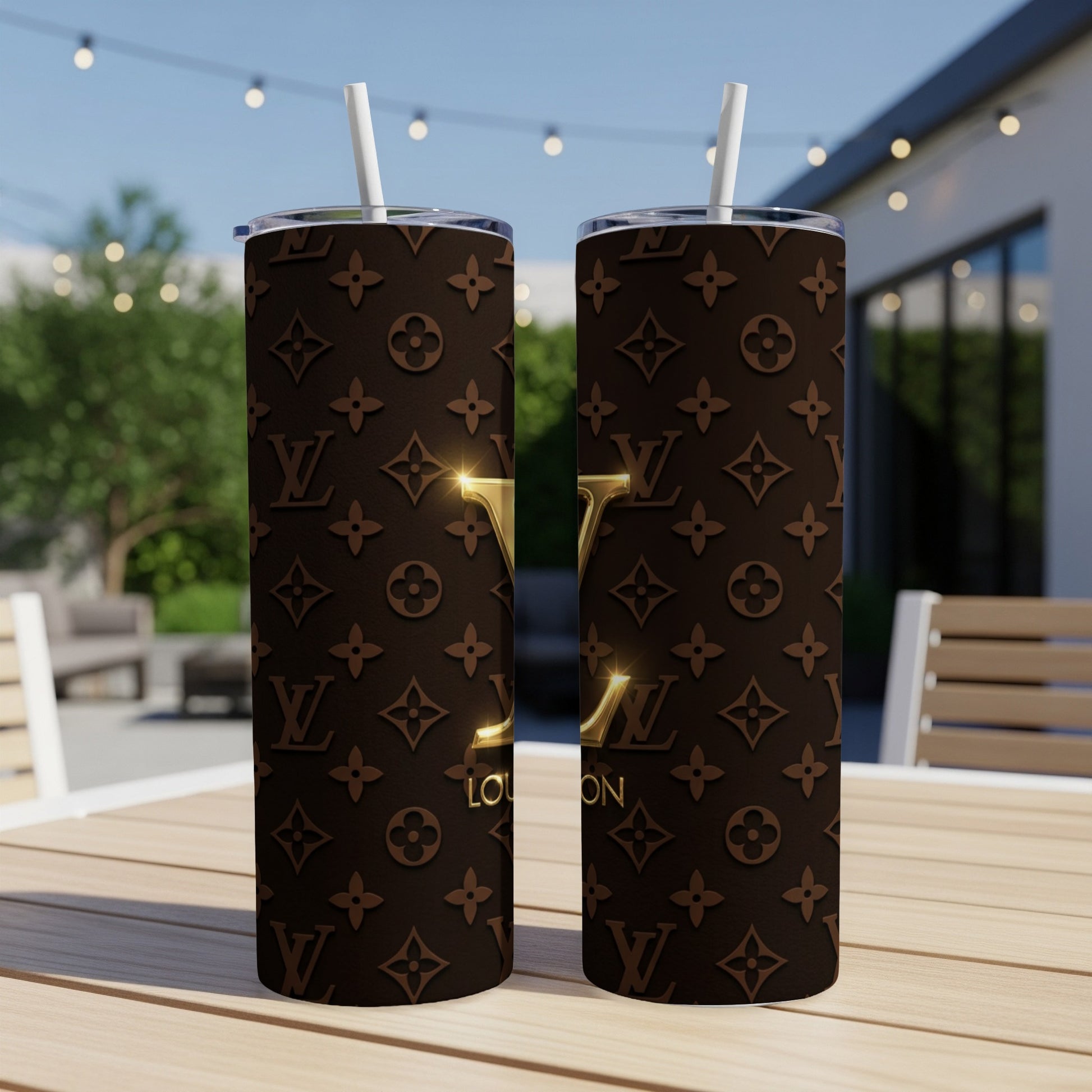 Two brown tumblers with gold logos and floral pattern on wooden table.