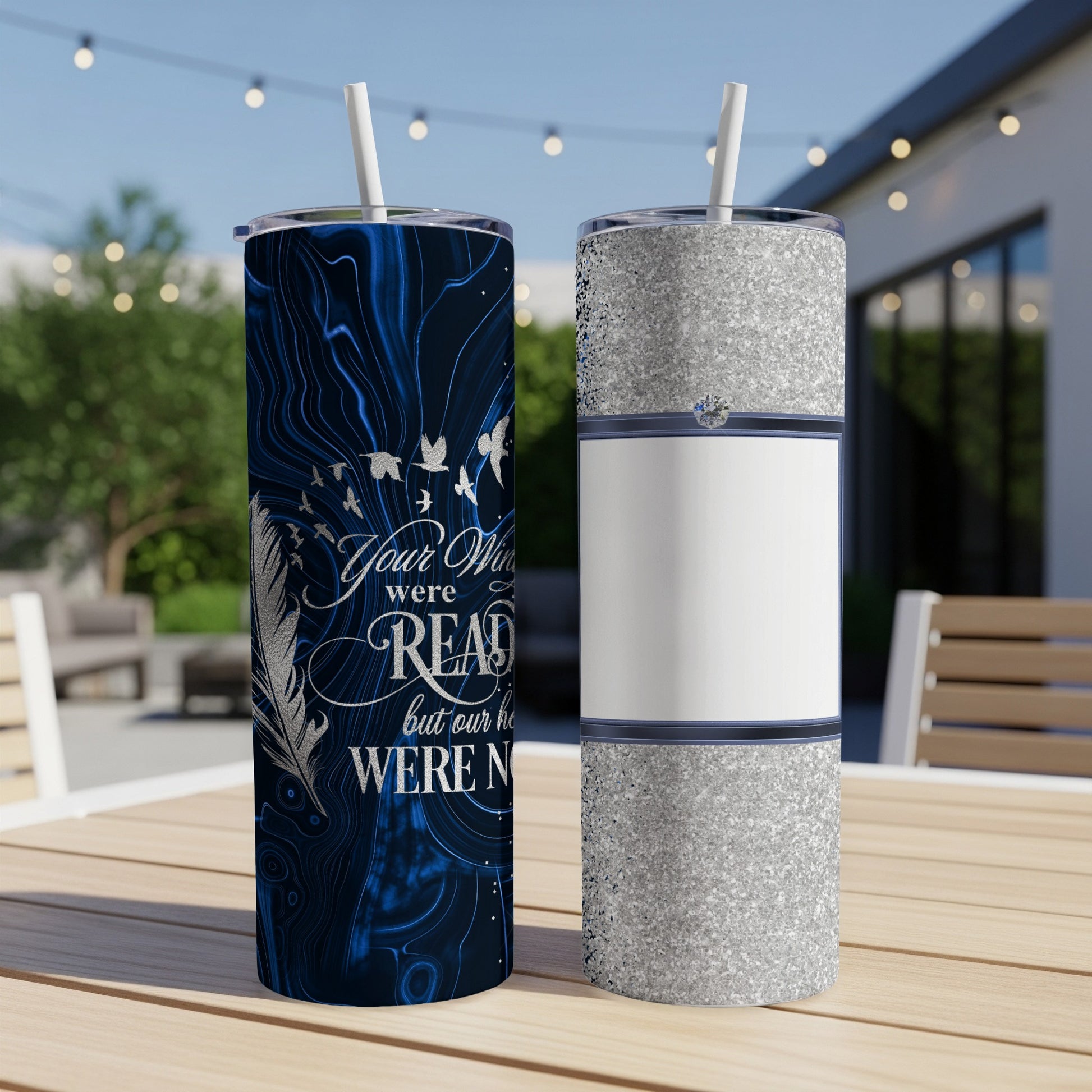 Dark blue marble tumbler with birds and memorial text, next to a silver glitter tumbler.