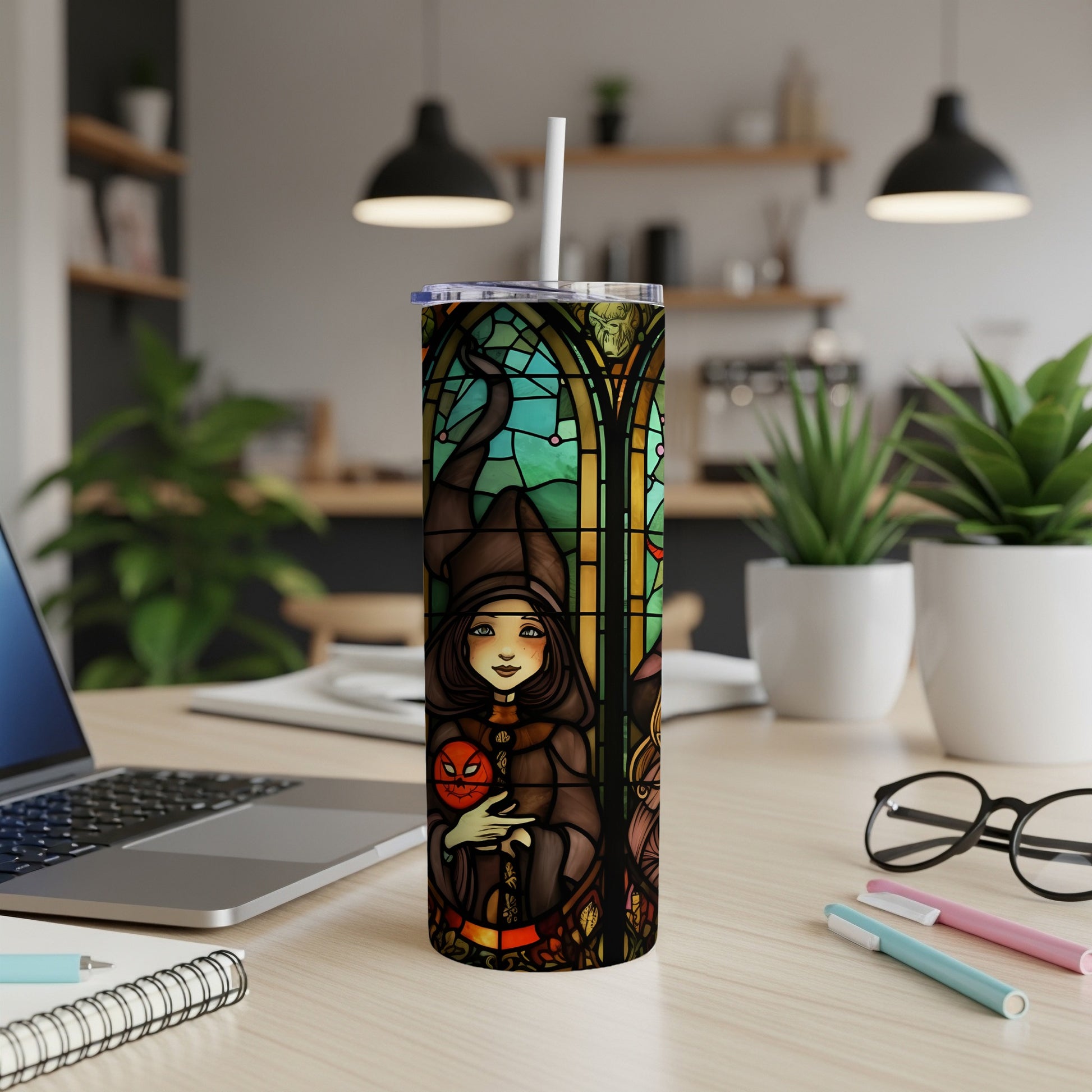 Stained glass tumbler with witch holding pumpkin and autumnal motifs.