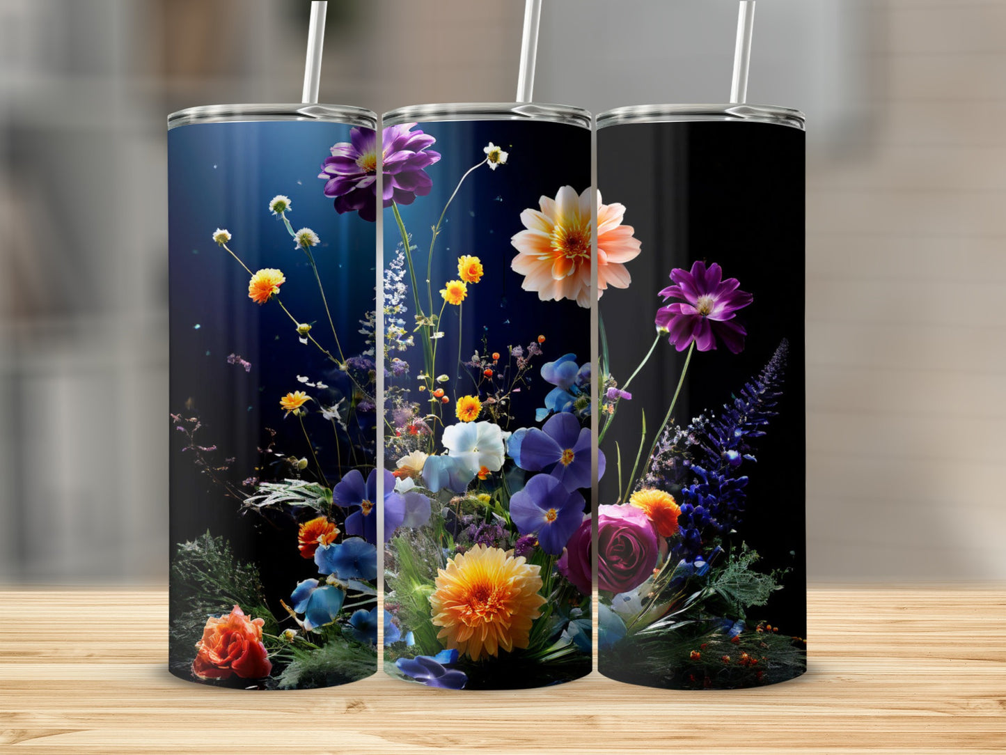 Three tumblers featuring colorful floral arrangements against a dark background.
