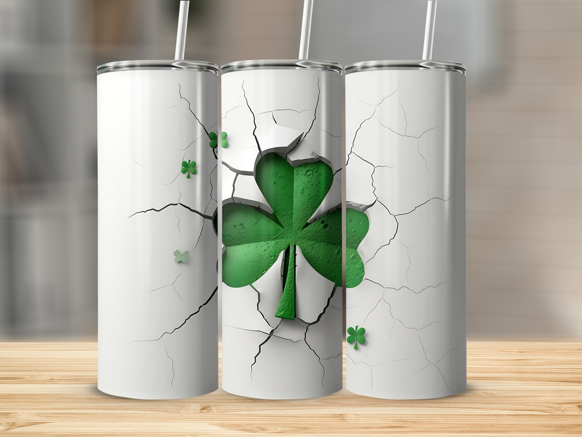 Three white tumblers with green cracked shamrock design and straws.