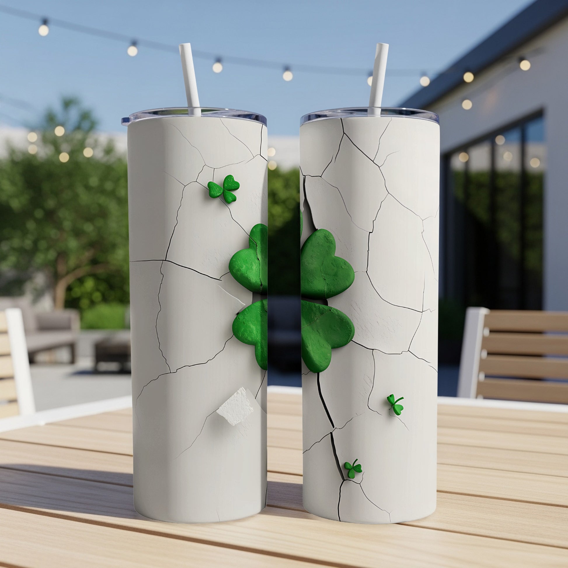 Cracked white tumbler with green shamrocks on a wooden table outdoors.