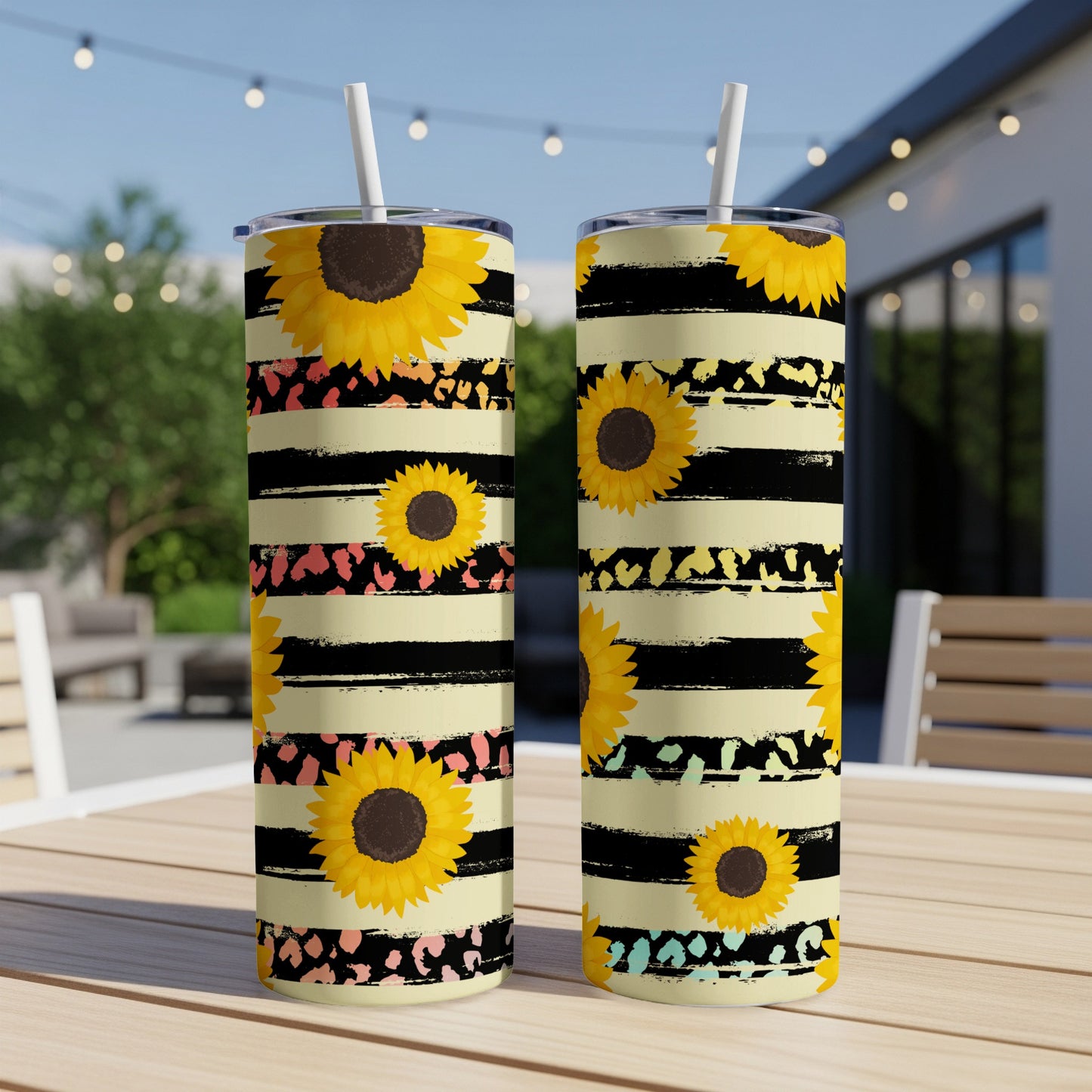 Two tall tumblers with sunflowers on a black and yellow striped background.