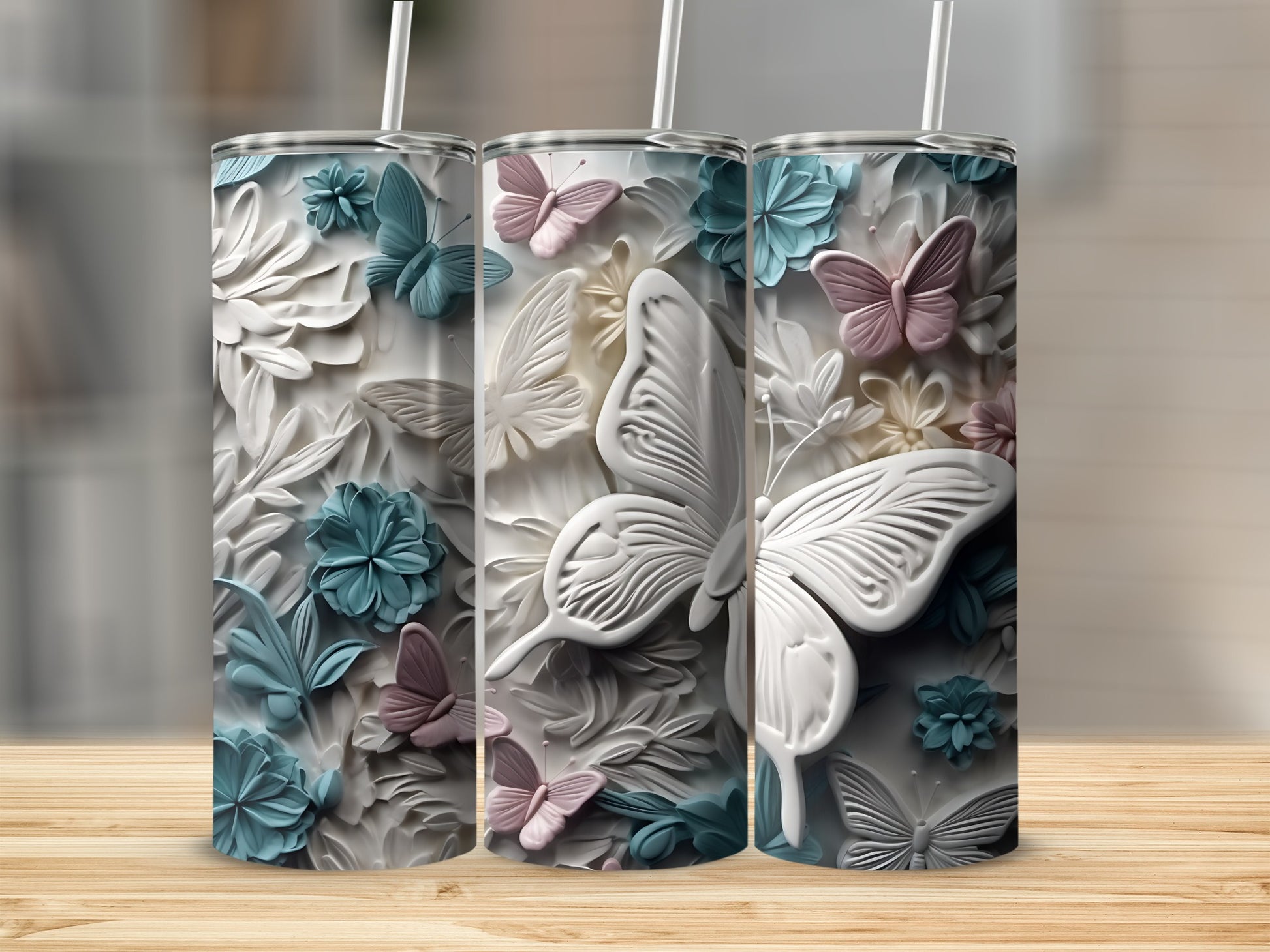 Three tall tumblers with raised butterfly and floral relief patterns.