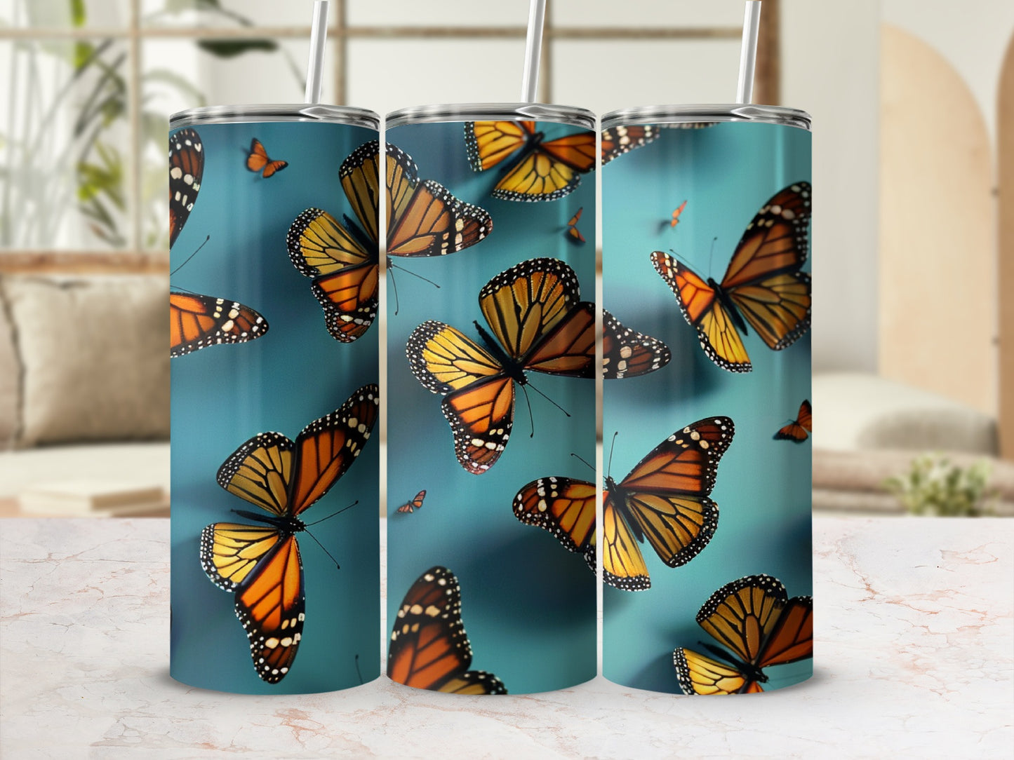 Monarch butterflies on a teal background, on a set of three tumblers.