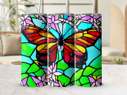 Three stained glass butterfly tumblers with vibrant colors on a patterned surface.