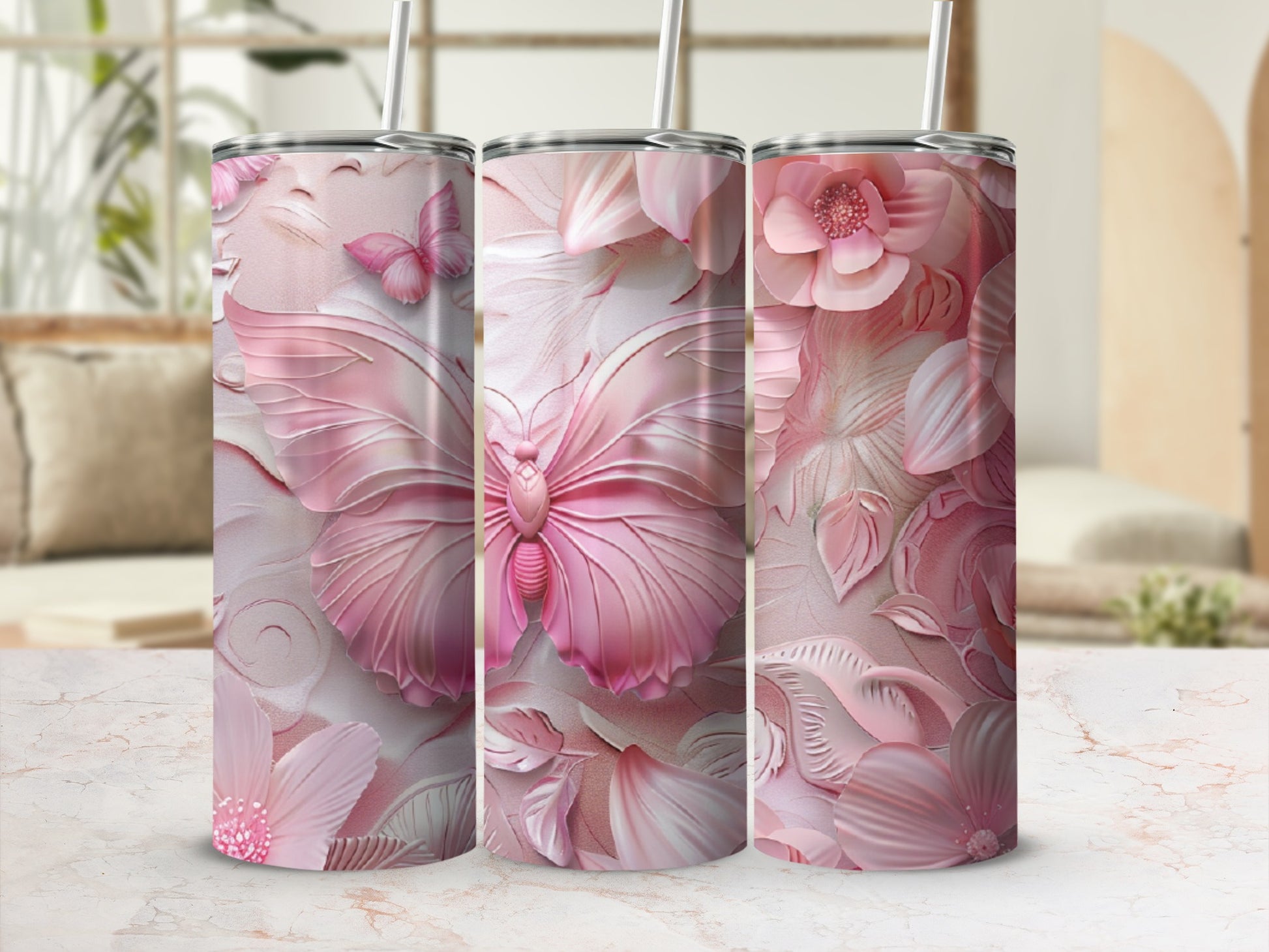 Pink butterfly and floral embossed stainless steel tumblers with straws.