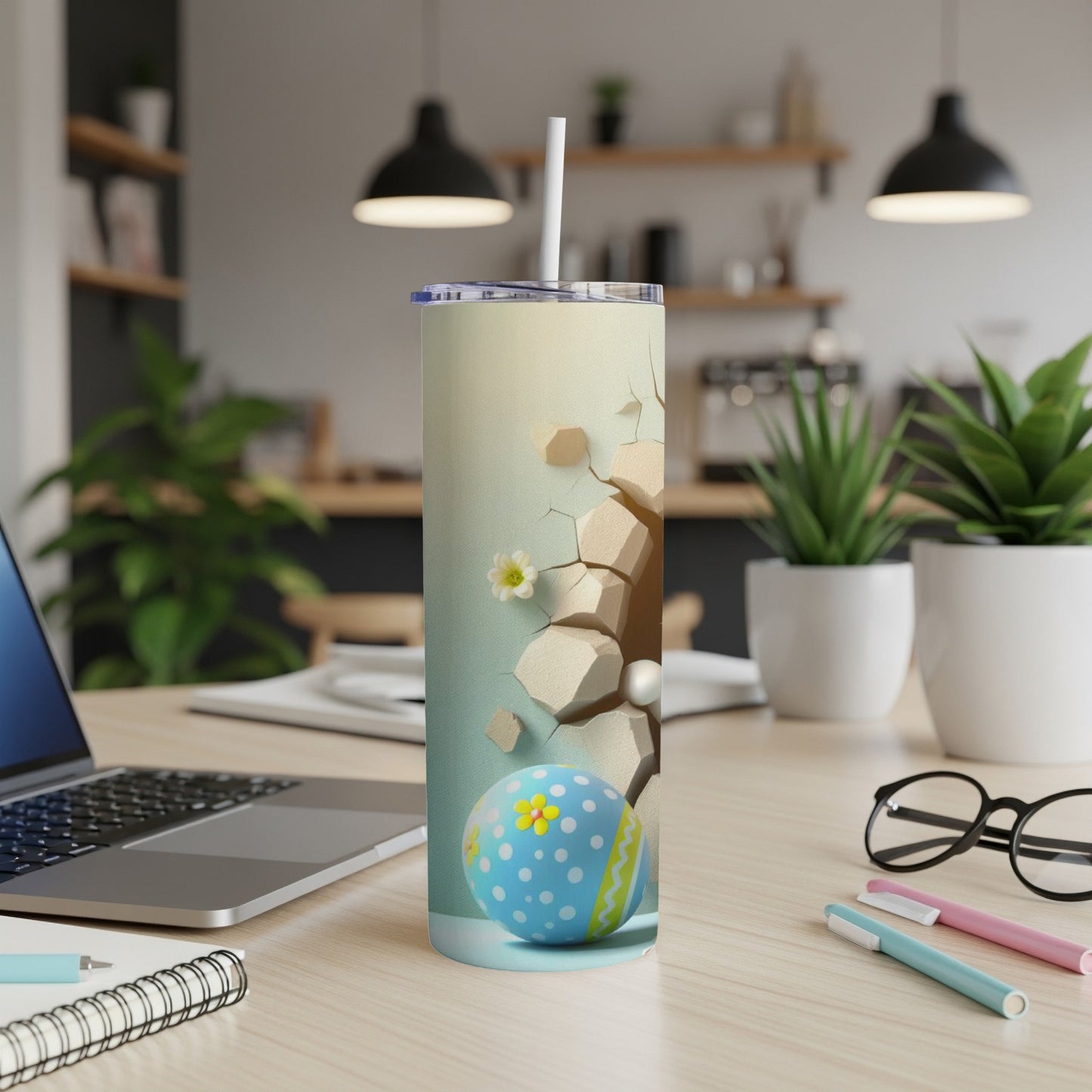 Easter egg design on a white tumbler with a straw, placed on a desk.