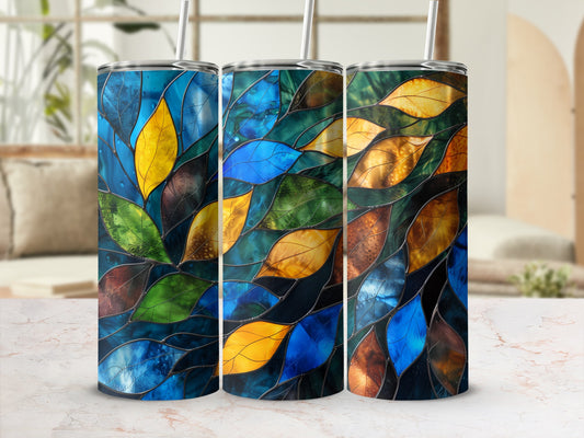 Three stained glass tumblers with colorful leaf designs and straws.