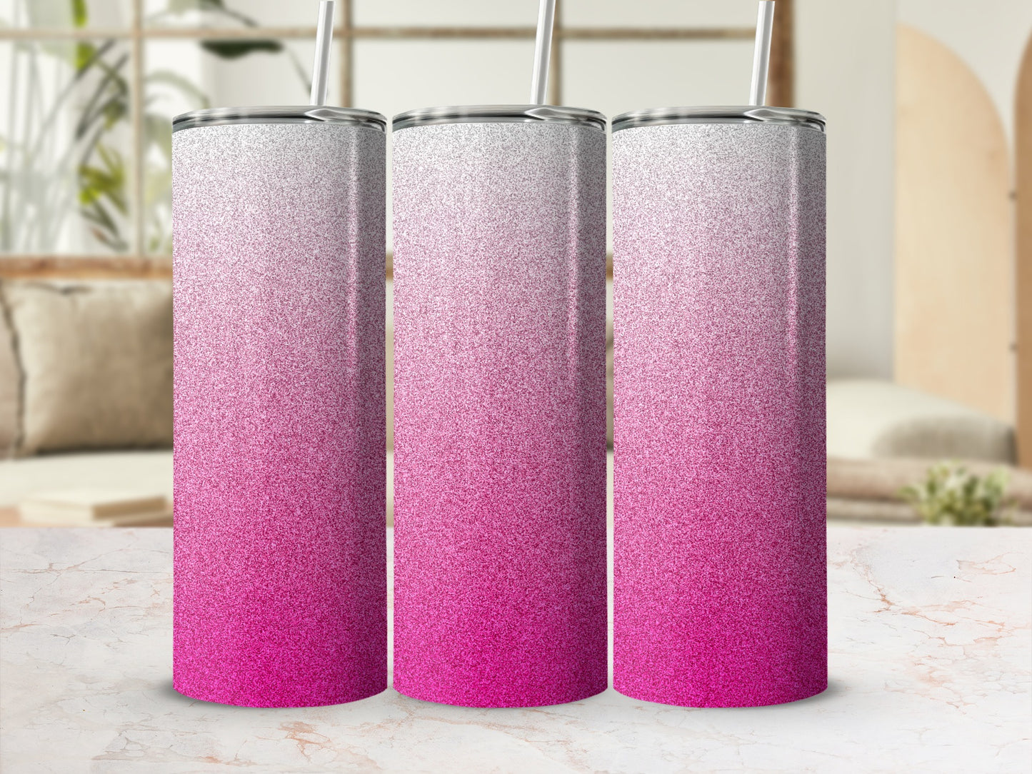 Three glitter tumblers with pink and white gradient on a marble countertop.