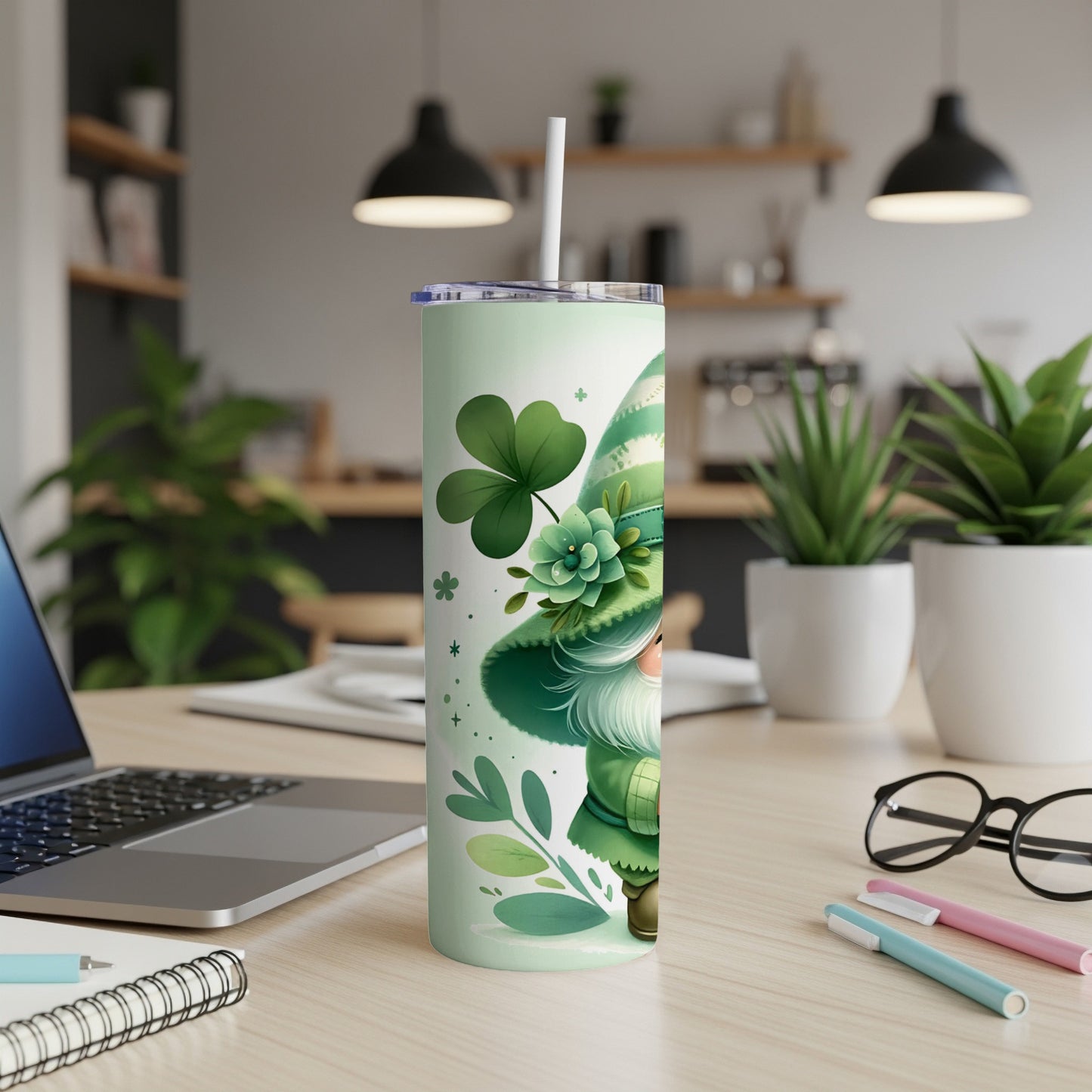 Green gnome and shamrocks on a tumbler with a straw on a desk.