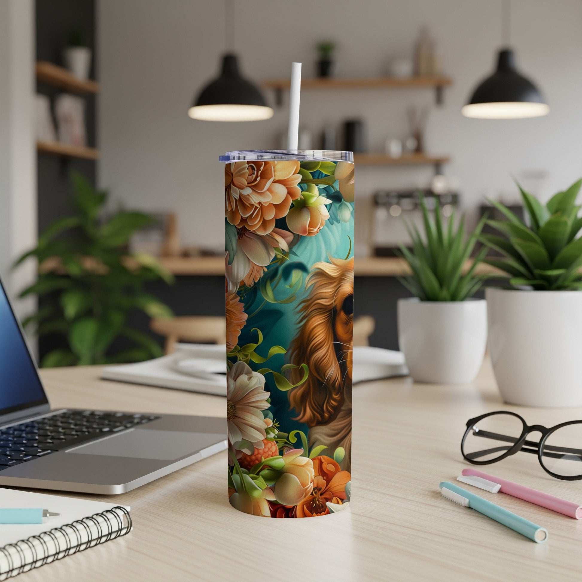 Floral tumbler with dog portrait, white straw, on desk with laptop and pens.
