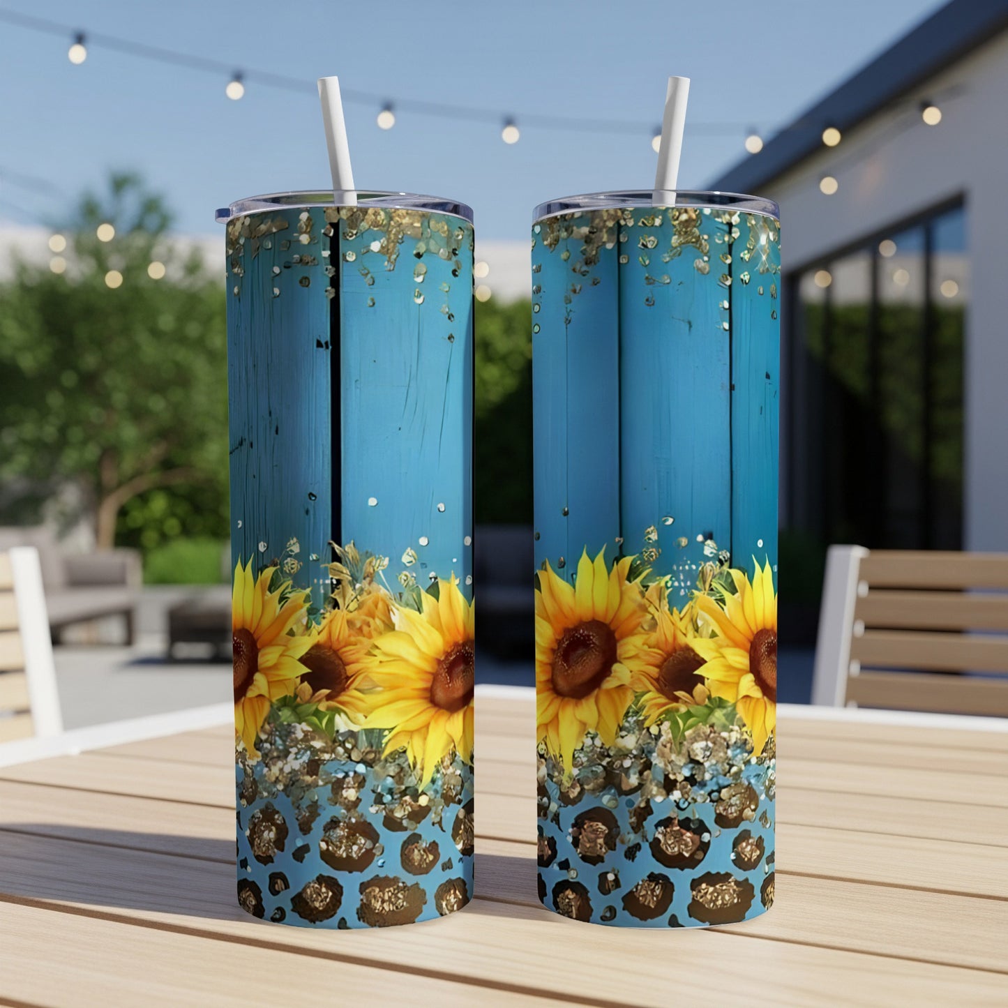 Two tall tumblers with sunflowers and leopard print on a wooden table.