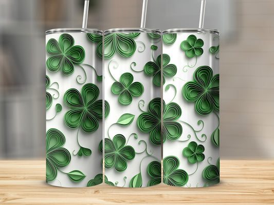 Three white tumblers with a green clover pattern and straws.