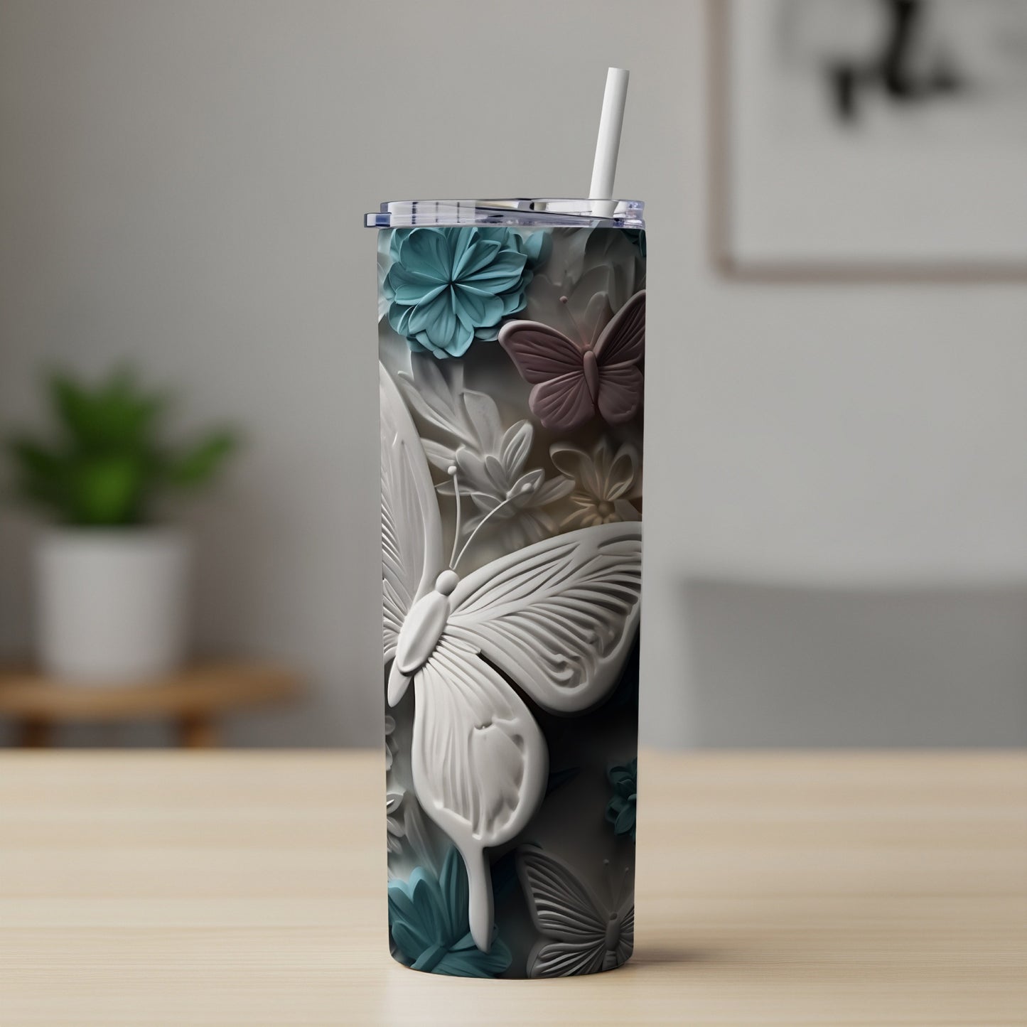 White and blue butterfly relief on a patterned tumbler with straw.