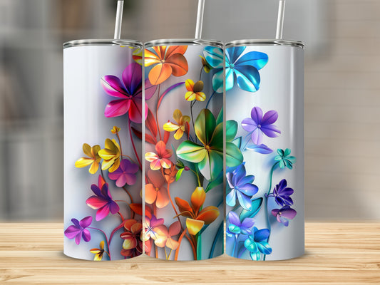 Three tumblers with colorful floral designs stand on a wooden surface.
