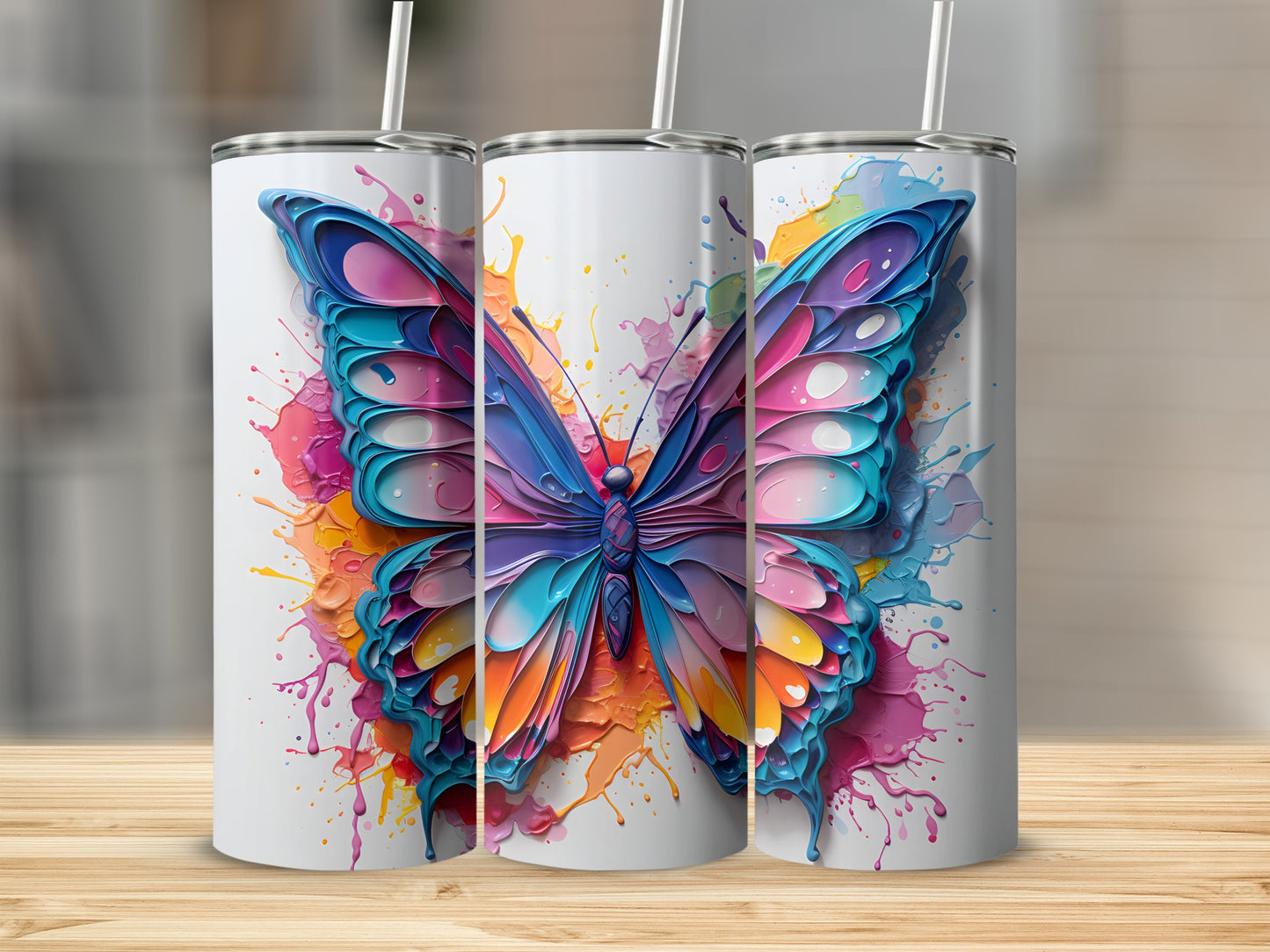 Three white tumblers with colorful butterfly and paint splash designs.